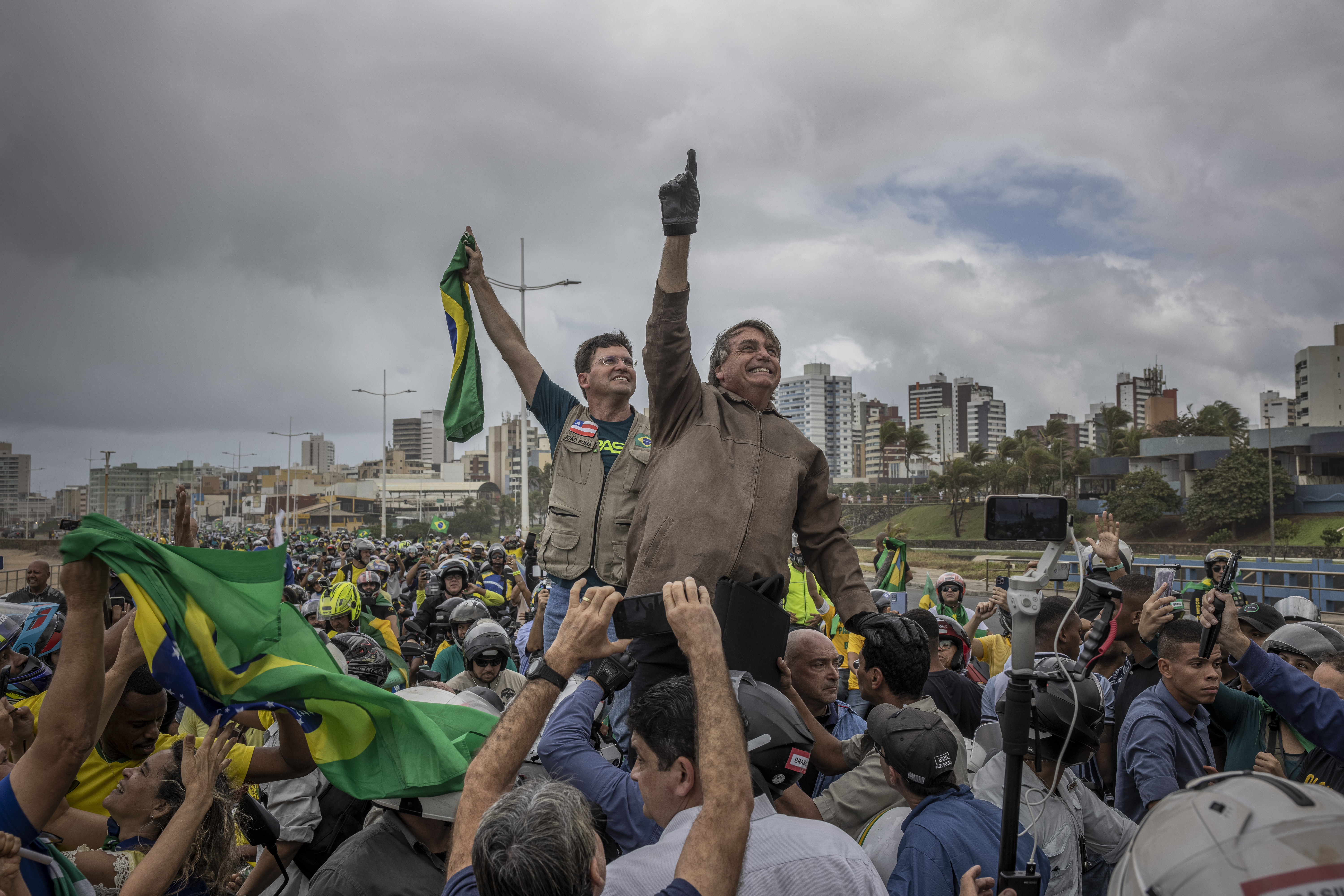 El presidente Jair Bolsonaro señala hacia el cielo mientras está rodeado de partidarios en un mitin el 2 de julio de 2022, en Salvador, Brasil. (Foto Prensa Libre: Victor Moriyama/The New York Times)