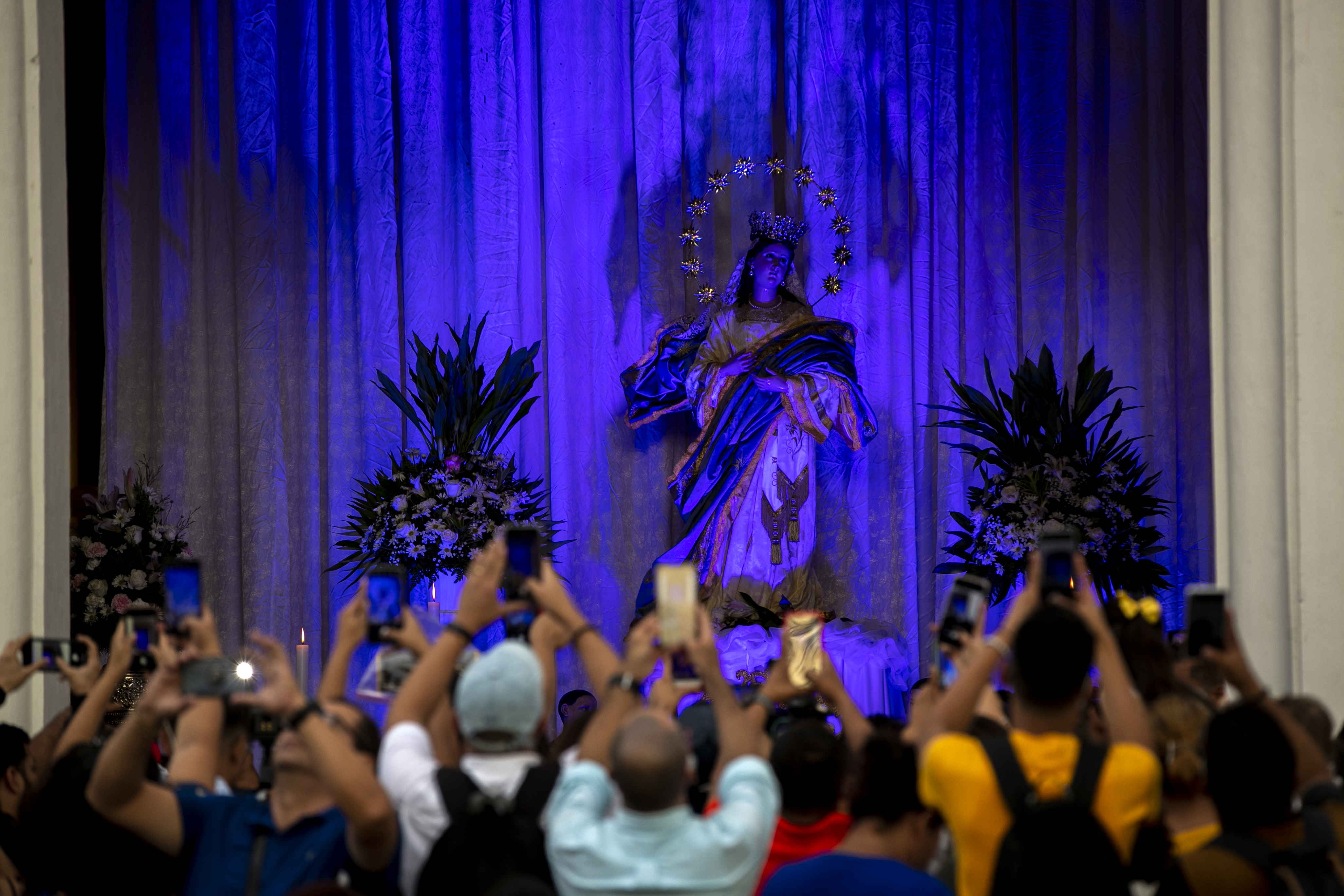 Feligreses le toman fotos a una imagen de la Virgen de la Asunción, durante la celebración de la Gritería Chiquita en León, mientras el gobierno de Daniel Ortega sigue arremetiendo contra sacerdotes. (Foto Prensa Libre: EFE)