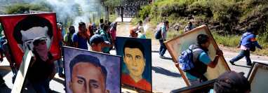 En esta foto de archivo tomada en  septiembre del 2015, estudiantes del colegio rural de  Ayotzinapa sostienen retratos de los 43 estudiantes que entonces estaban considerados como desaparecidos. (Foto Prensa Libre: AFP)