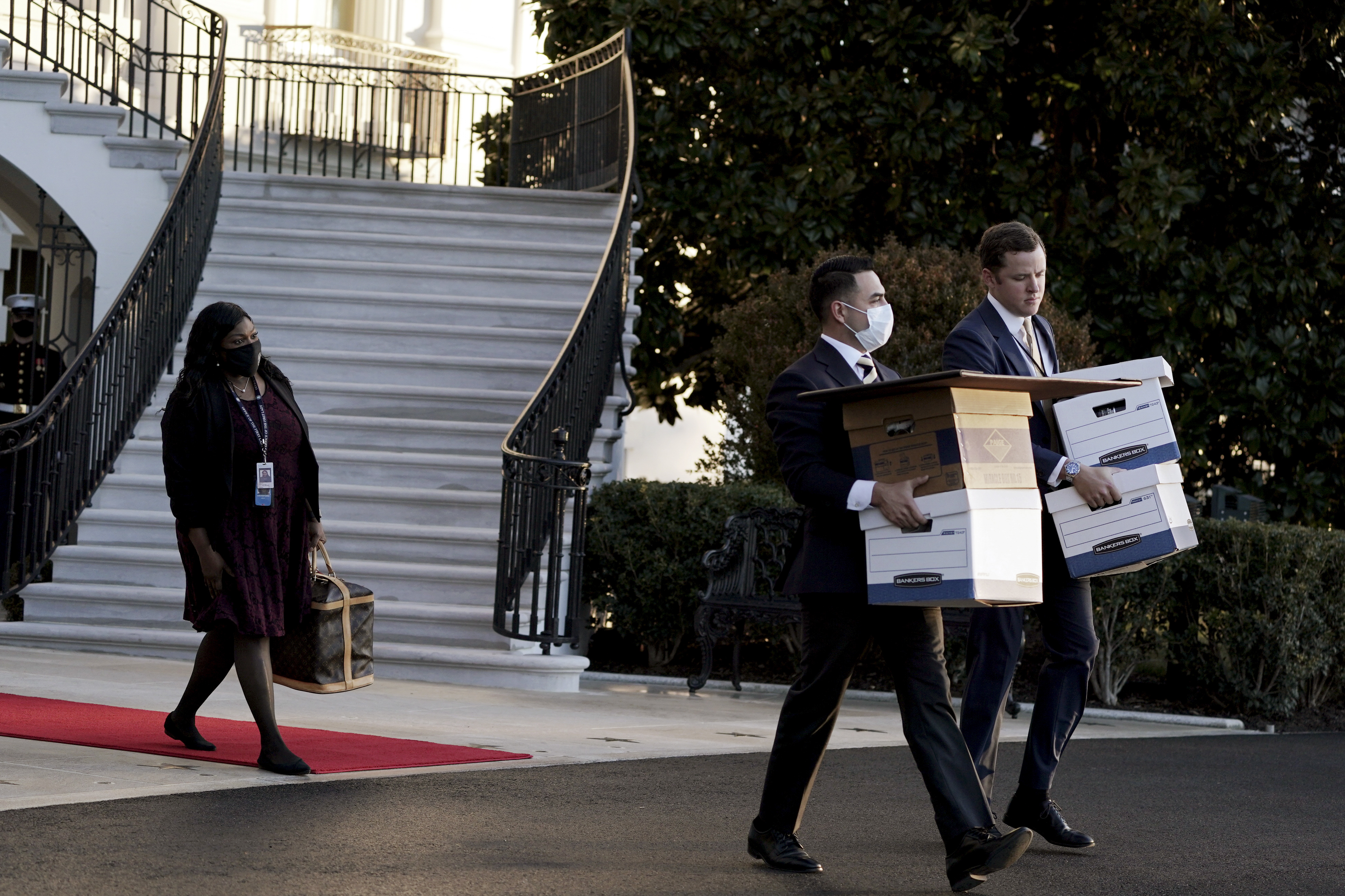 Los ayudantes sacan cajas de la Casa Blanca mientras el presidente Donald Trump se prepara para subir al Marine One en su último día como presidente, en Washington el 20 de enero de 2021. (Foto Prensa Libre: Anna Moneymaker/The New York Times)