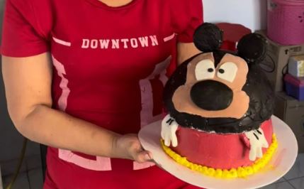 Fotografía de Marjorie Romero y su torta de Mickey Mouse