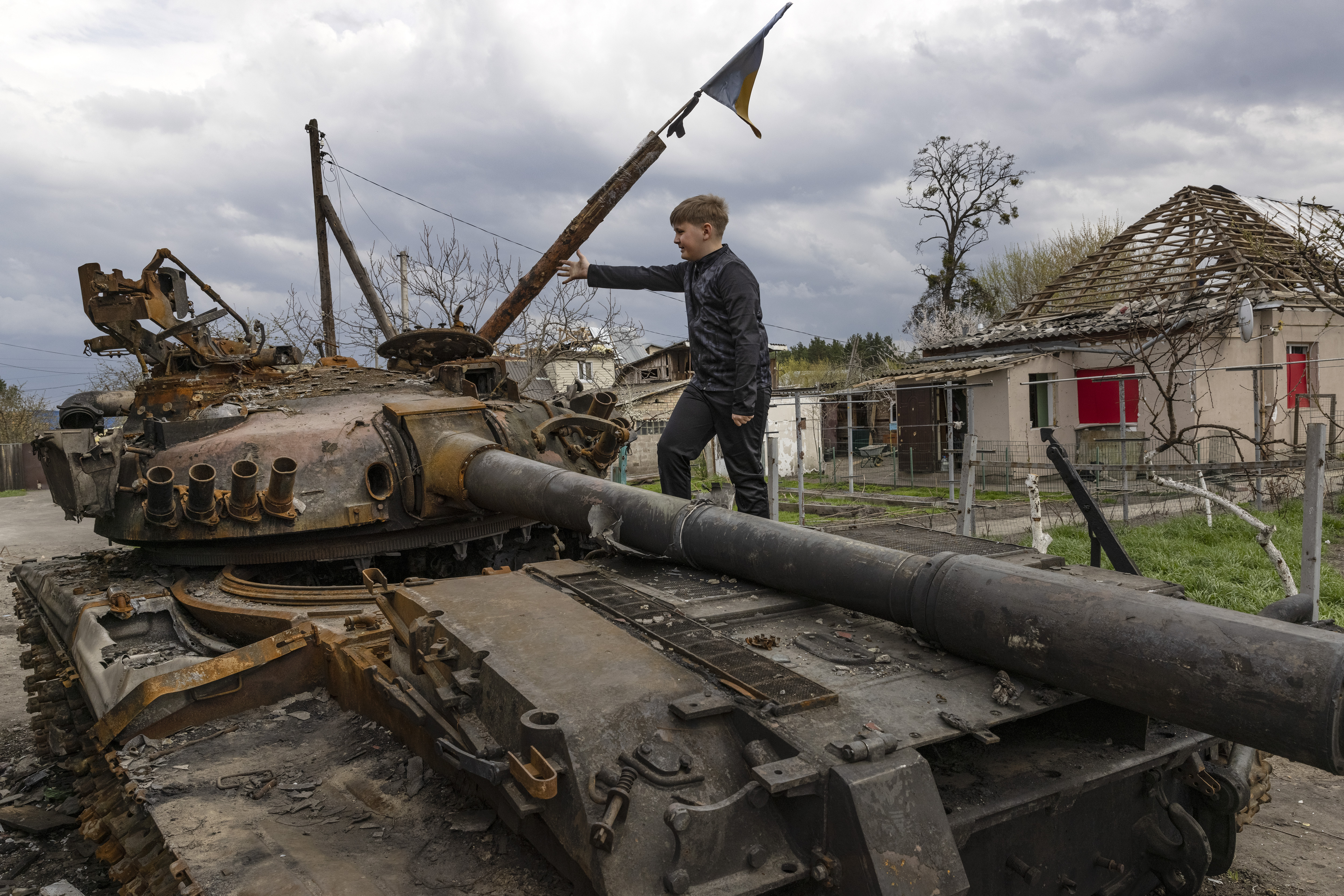 Alexander Buriak sube a un tanque destruido entre edificios en ruinas en Hostomel, Ucrania, 25 de abril de 2022. (Foto Prensa Libre: David Guttenfelder/The New York Times)