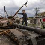 Alexander Buriak sube a un tanque destruido entre edificios en ruinas en Hostomel, Ucrania, 25 de abril de 2022. (Foto Prensa Libre: David Guttenfelder/The New York Times)
