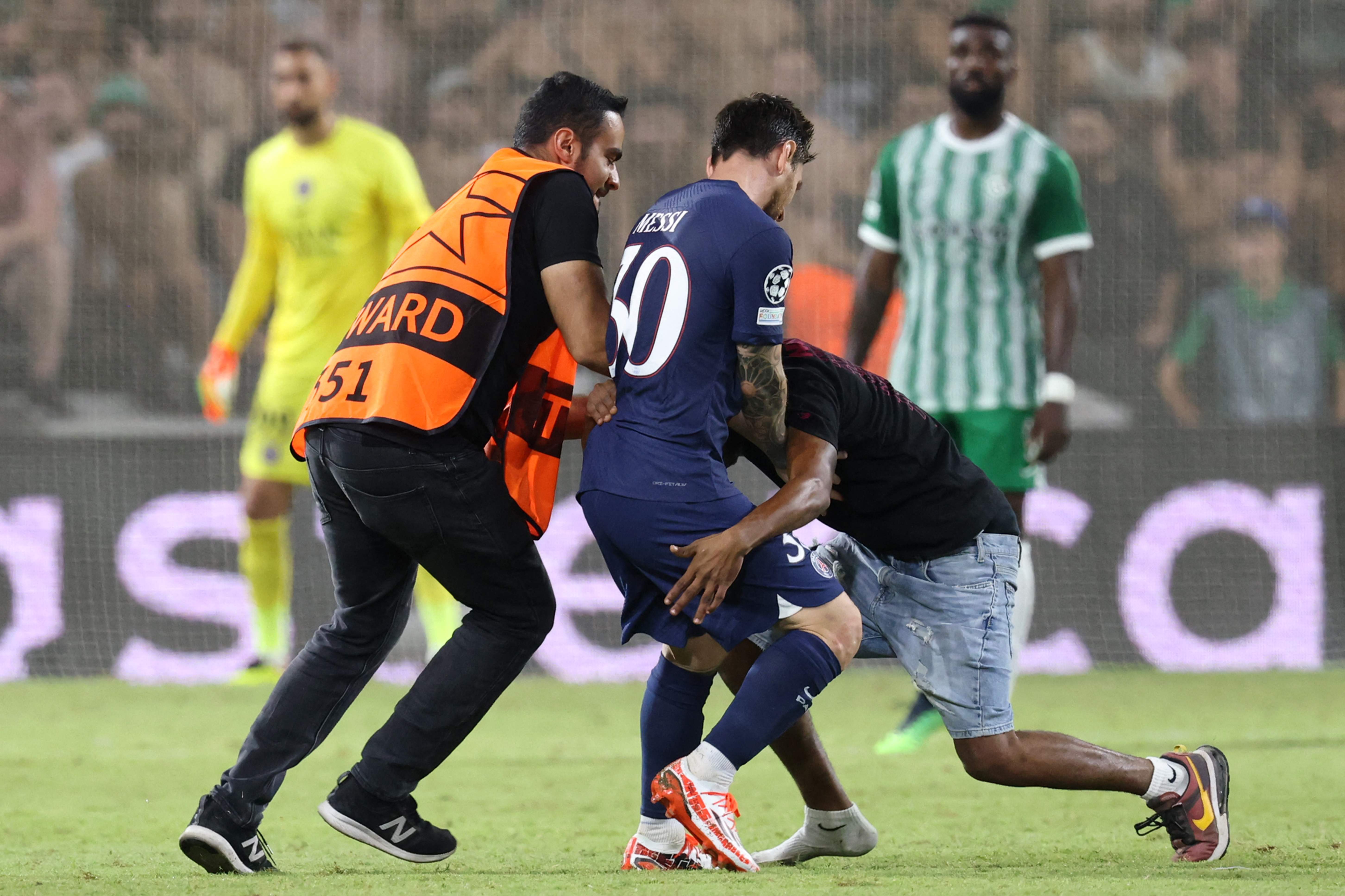 Lionel Messi en el momento que un aficionado intenta abrazarlo en el partido de este miércoles en Israel. (Foto Prensa Libre: AFP).