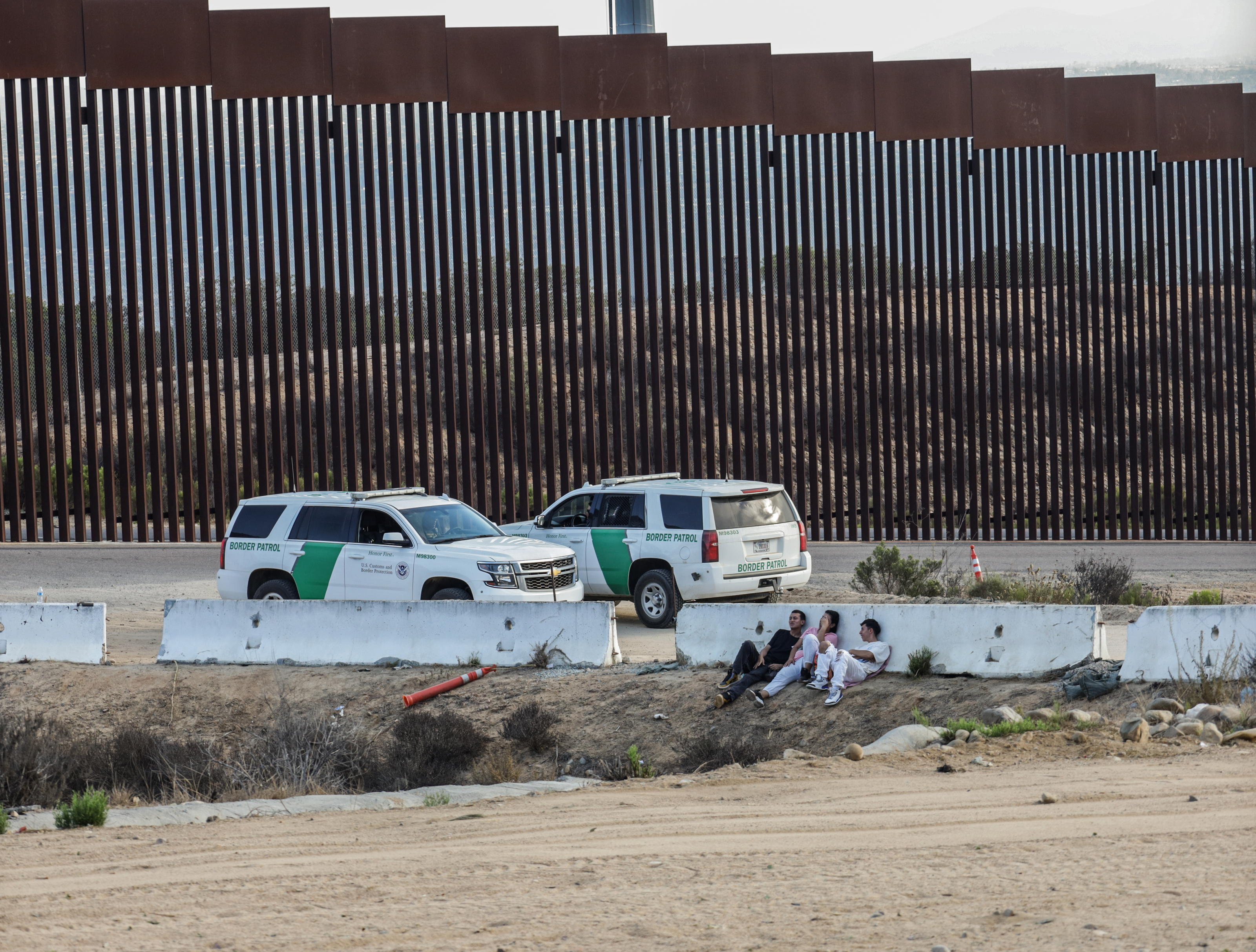  Migrantes esperan la oportunidad para cruzar el muro fronterizo entre México y EE. UU. (Foto Prensa Libre: EFE)
