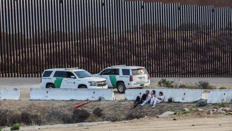  Migrantes esperan la oportunidad para cruzar el muro fronterizo entre México y EE. UU. (Foto Prensa Libre: EFE)