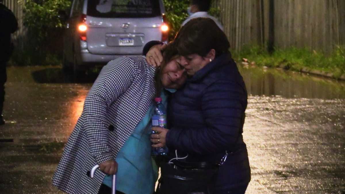 Mayra Gutiérrez, familiar de una de las víctimas de la tragedia, es consolada en las afueras de la morgue del Inacif. (Foto Prensa Libre: Mynor Toc)