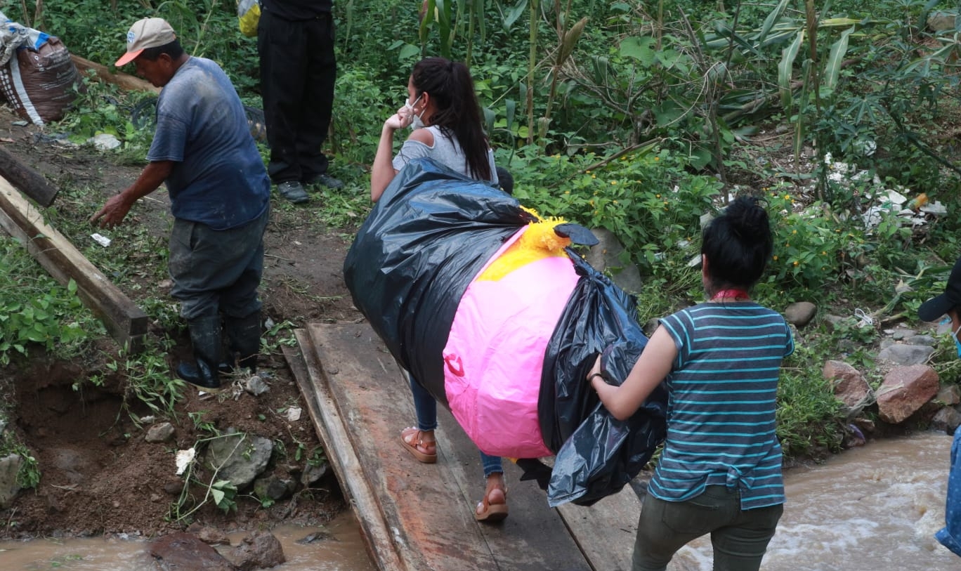 Los habitantes de San pedro Ayampuc solicitan ayuda de las autoridades para rellenar el socavón registrado en el kilómetro 14.5, el cual los mantiene incomunicados. (Foto Prensa Libre: María José Bonilla)