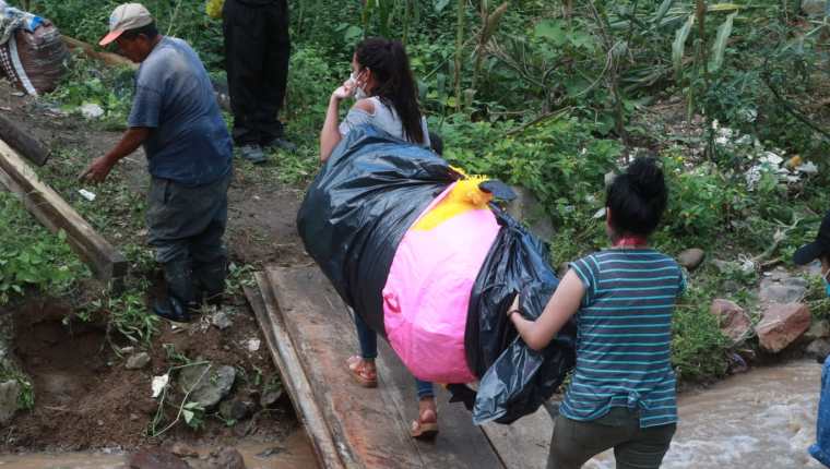 Los habitantes de San pedro Ayampuc solicitan ayuda de las autoridades para rellenar el socavón registrado en el kilómetro 14.5, el cual los mantiene incomunicados. (Foto Prensa Libre: María José Bonilla)