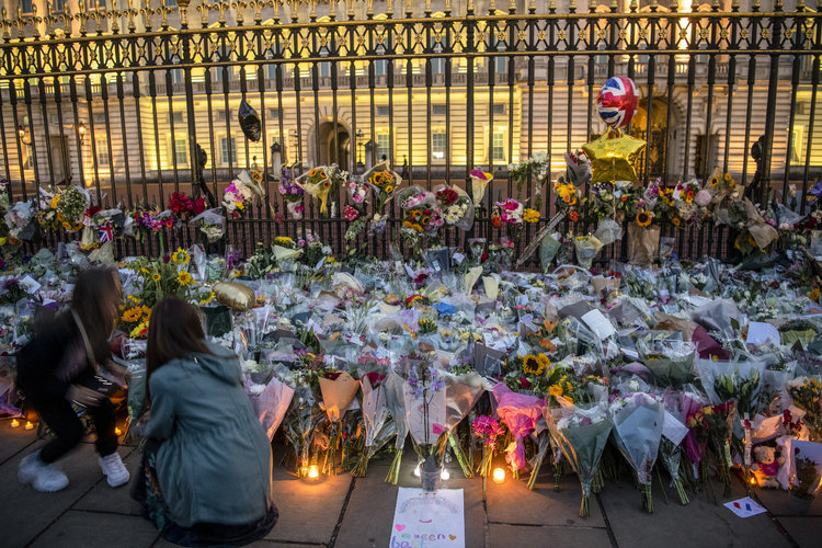 La gente deja flores frente al Palacio de Buckingham el día después de la muerte de la reina Isabel II en Londres, Inglaterra, el 9 de septiembre de 2022.  (Foto Prensa Libre: James Hill/The New York Times)