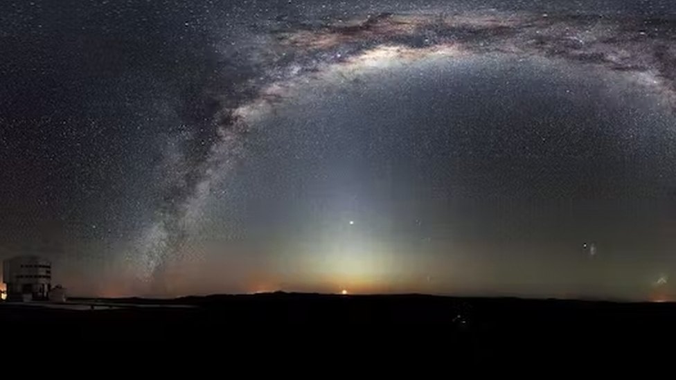La Vía Láctea se arquea a través de esta rara panorámica de 360 grados del cielo nocturno sobre la plataforma de Paranal, sede del Very Large Telescope de ESO. La Luna acaba de salir.