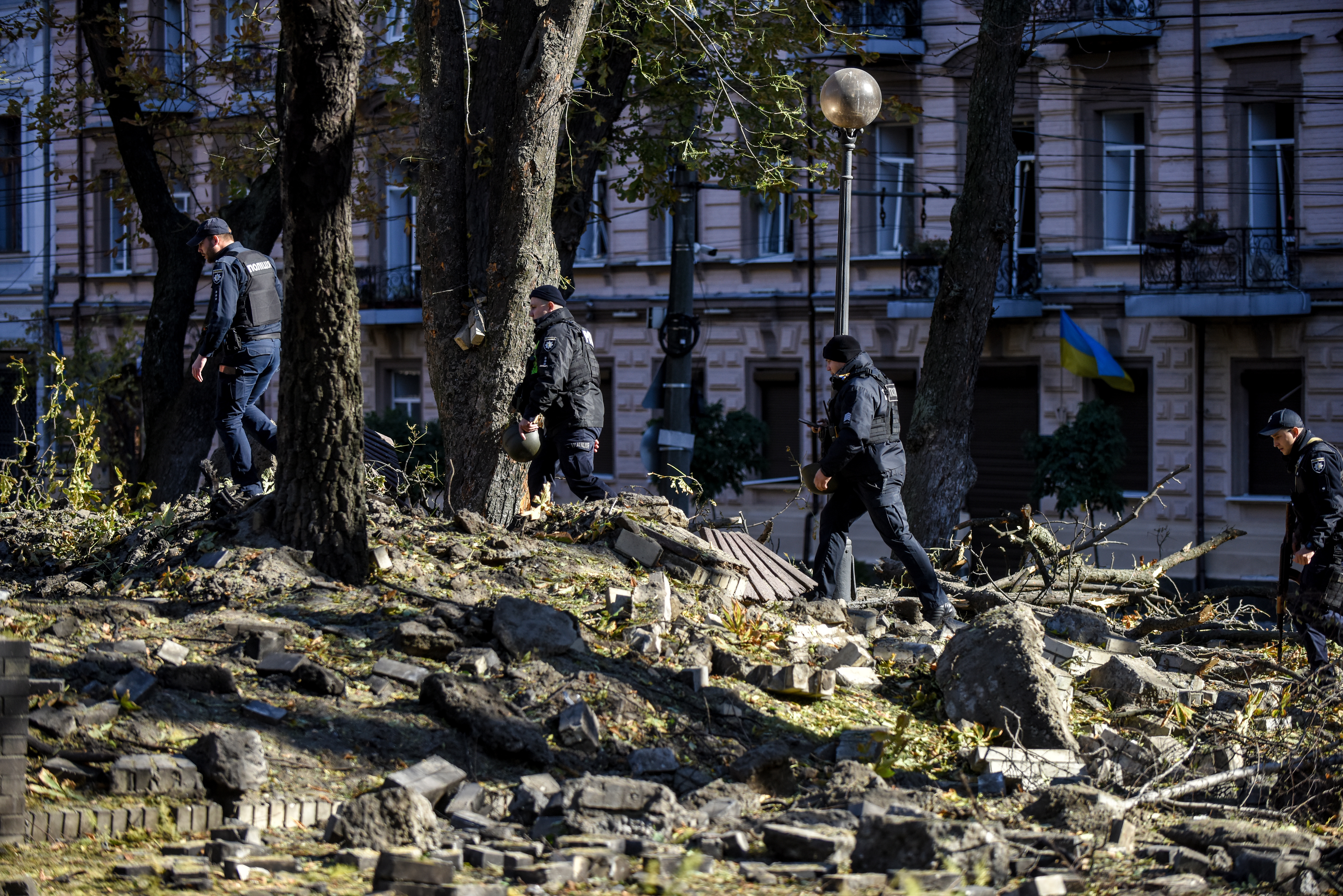 Oficiales de la policía caminan entre los escombros después de un bombardeo en Kiev. (Foto Prensa Libre: EFE)