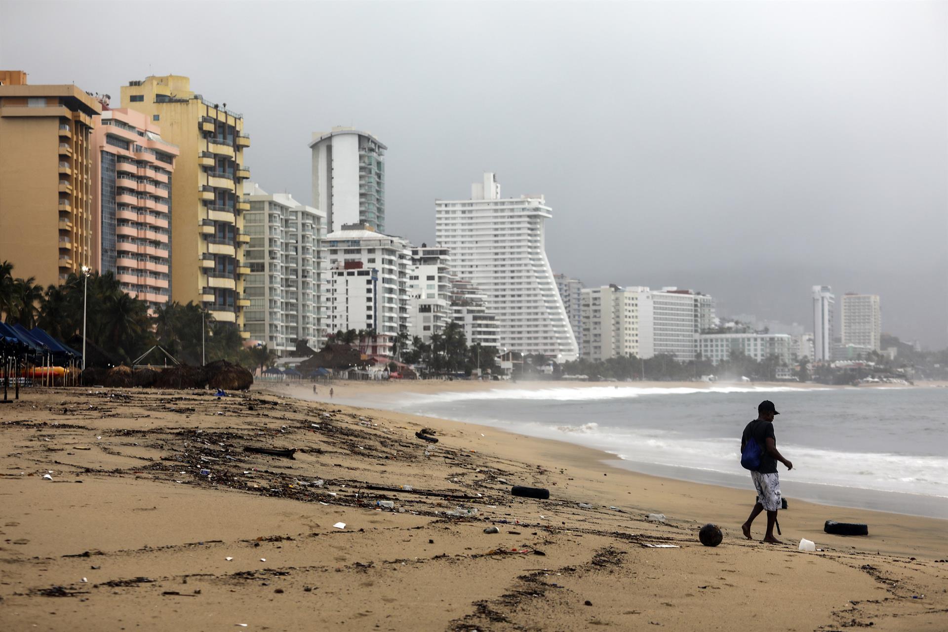 Una persona camina por una playa llena de basura debido a las fuertes lluvias en el balneario de Acapulco, estado de Guerrero (México). Imagen de archivo. (Foto Prensa Libre: EFE/ David Guzmán)