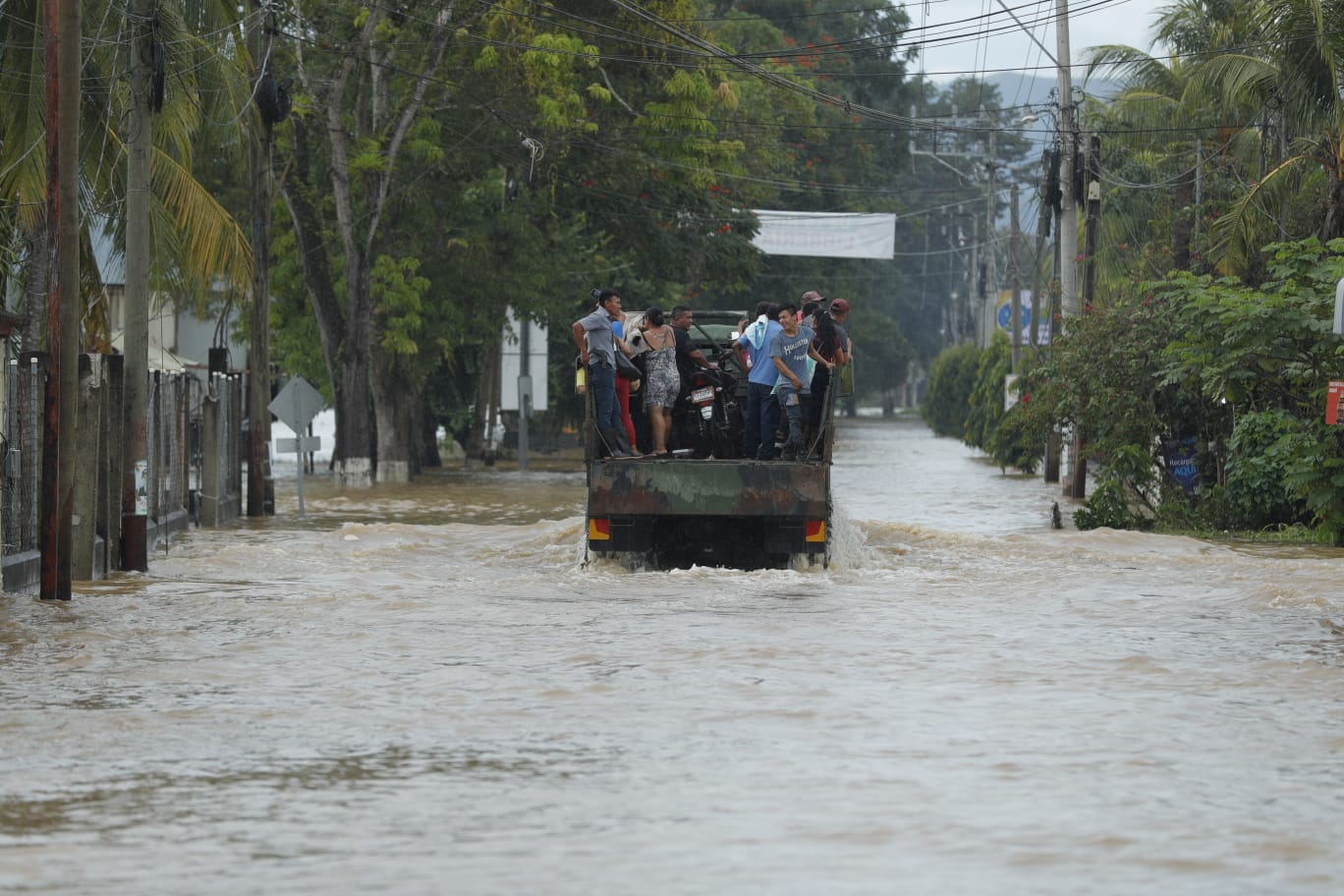 Pobladores se deben movilizar en camiones en Morales, Izabal, por las inundaciones por la depresión tropical Julia. (Foto Prensa Libre: Esbin García) 