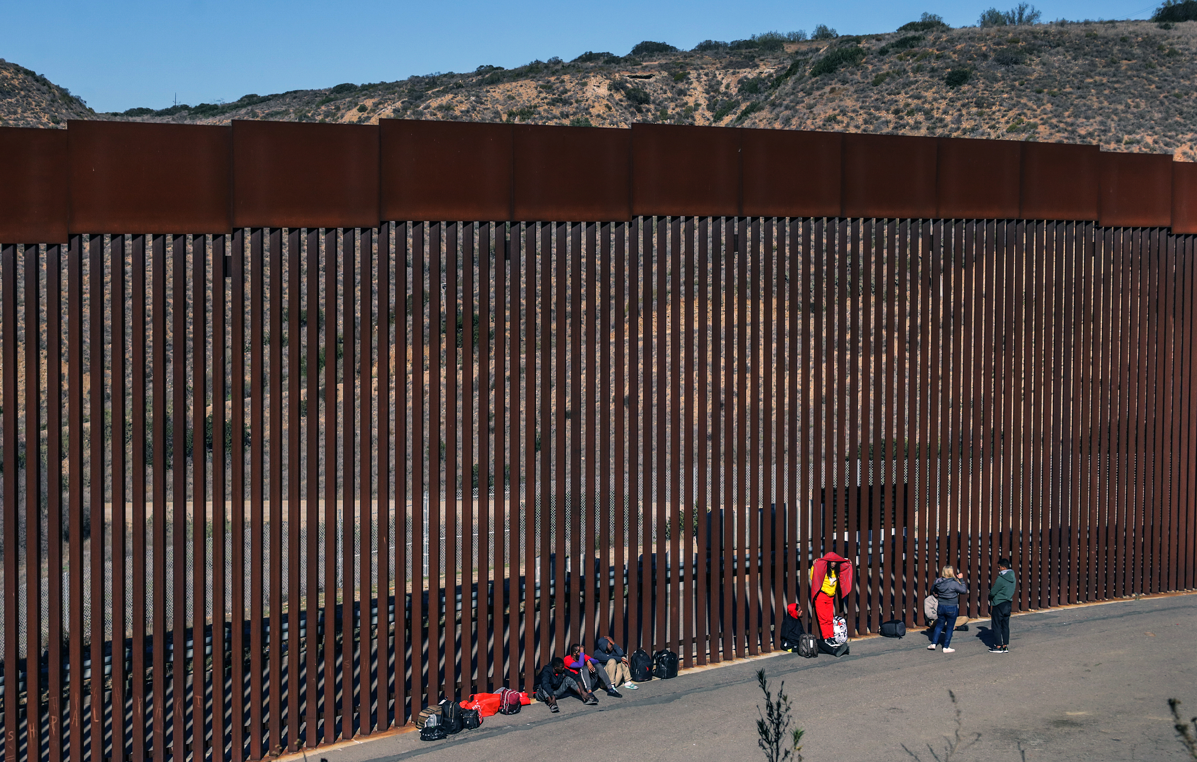 Migrantes permanecen a un costado del muro fronterizo con Estados Unidos, en Tijuana, Baja California, México. (Foto Prensa Libre: EFE)