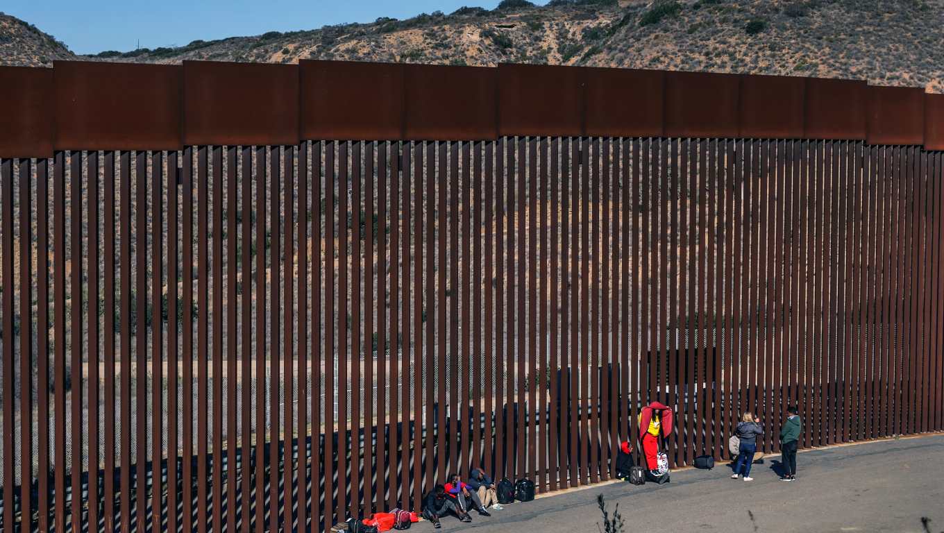 Migrantes permanecen a un costado del muro fronterizo con Estados Unidos, en Tijuana, Baja California, México. (Foto Prensa Libre: EFE)