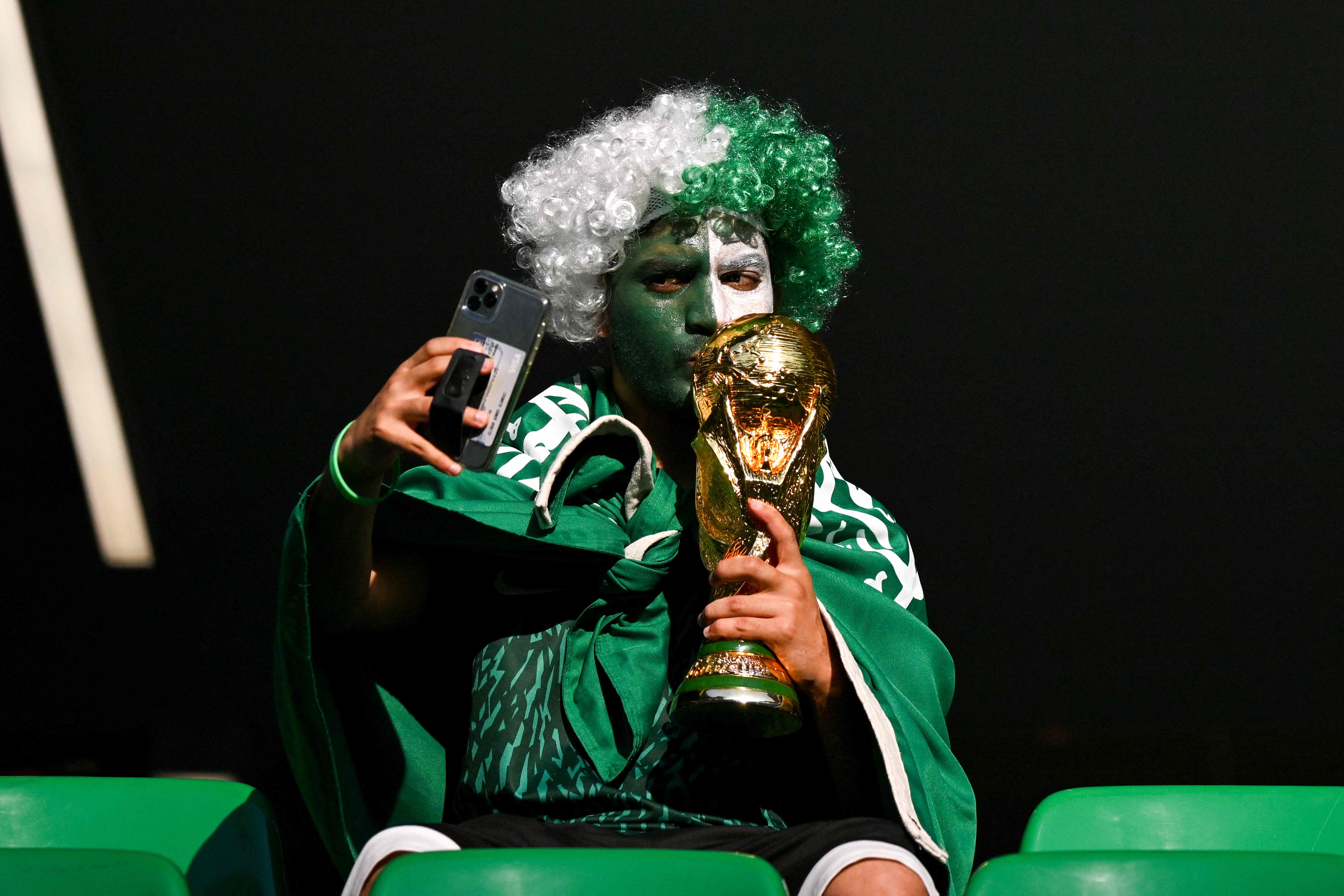 Un aficionado de Arabia Saudita con una replica del trofeo de la Copad del Mundo. Foto Prensa Libre (AFP) 