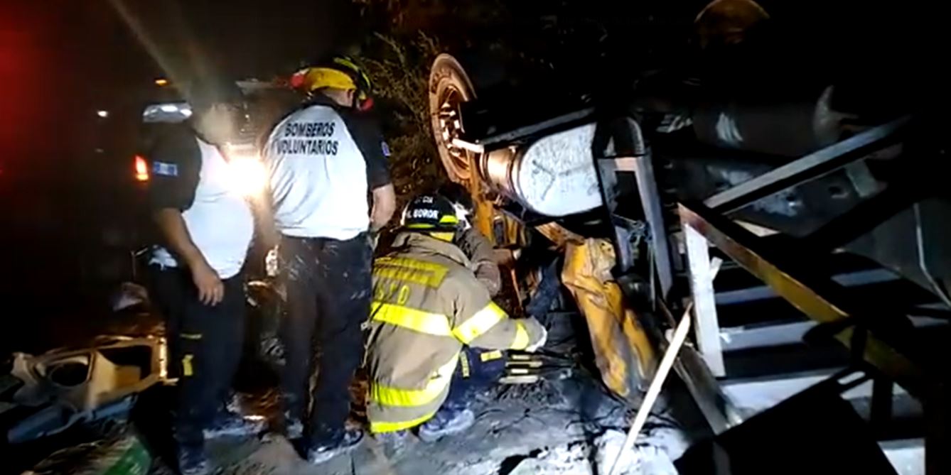 Socorristas utilizan equipo hidráulico para rescatar el cuerpo de un piloto de un camión accidentado en San Juan Sacatepéquez. (Foto Prensa Libre: Bomberos Voluntarios)