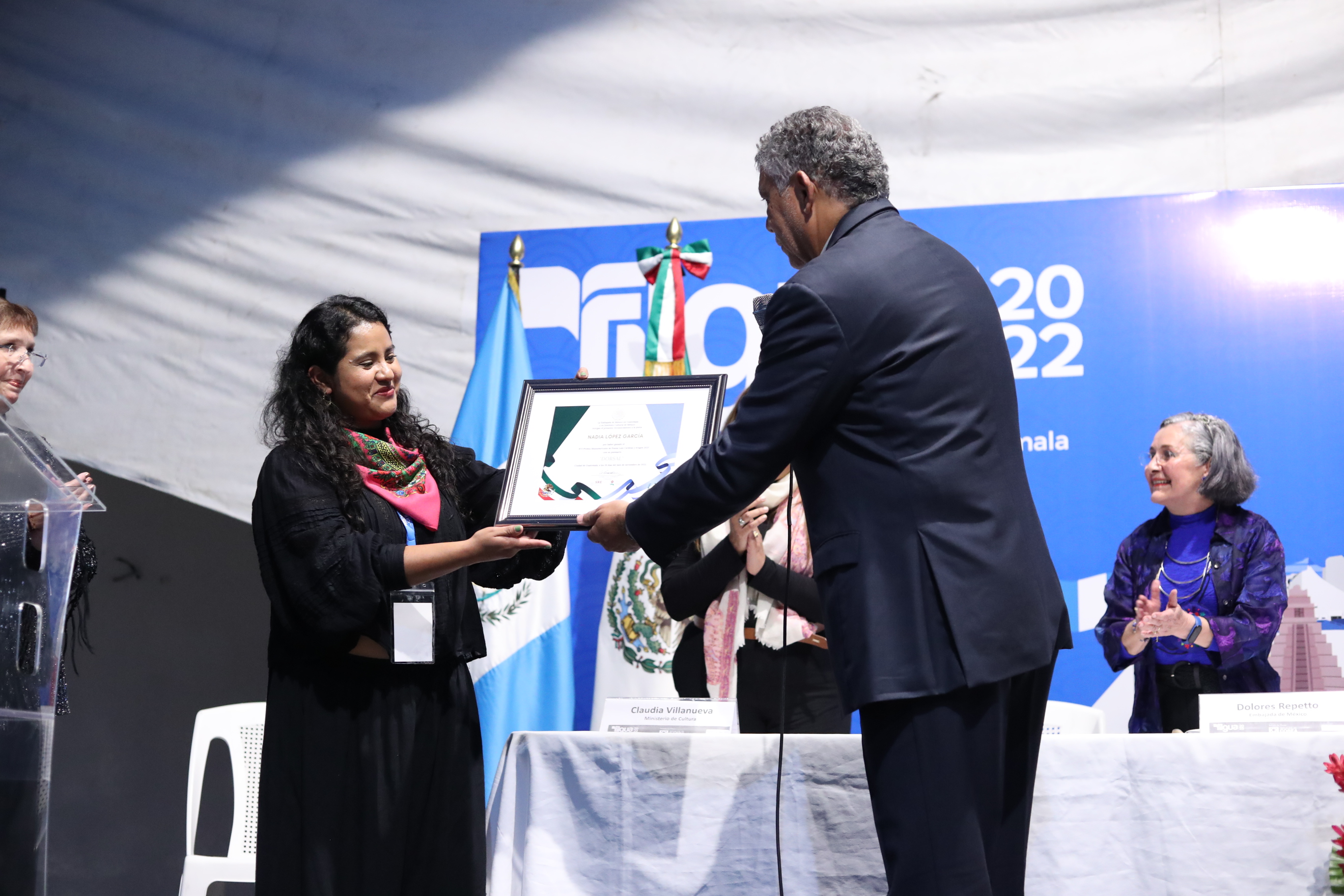 La escritora Nadia López García recibe el reconocimiento que entrega Edgar Alejandro López Hernández, director de Grupo Inversor Veracruzano, en Filgua 2022. (Foto Prensa Libre: Esbin García)