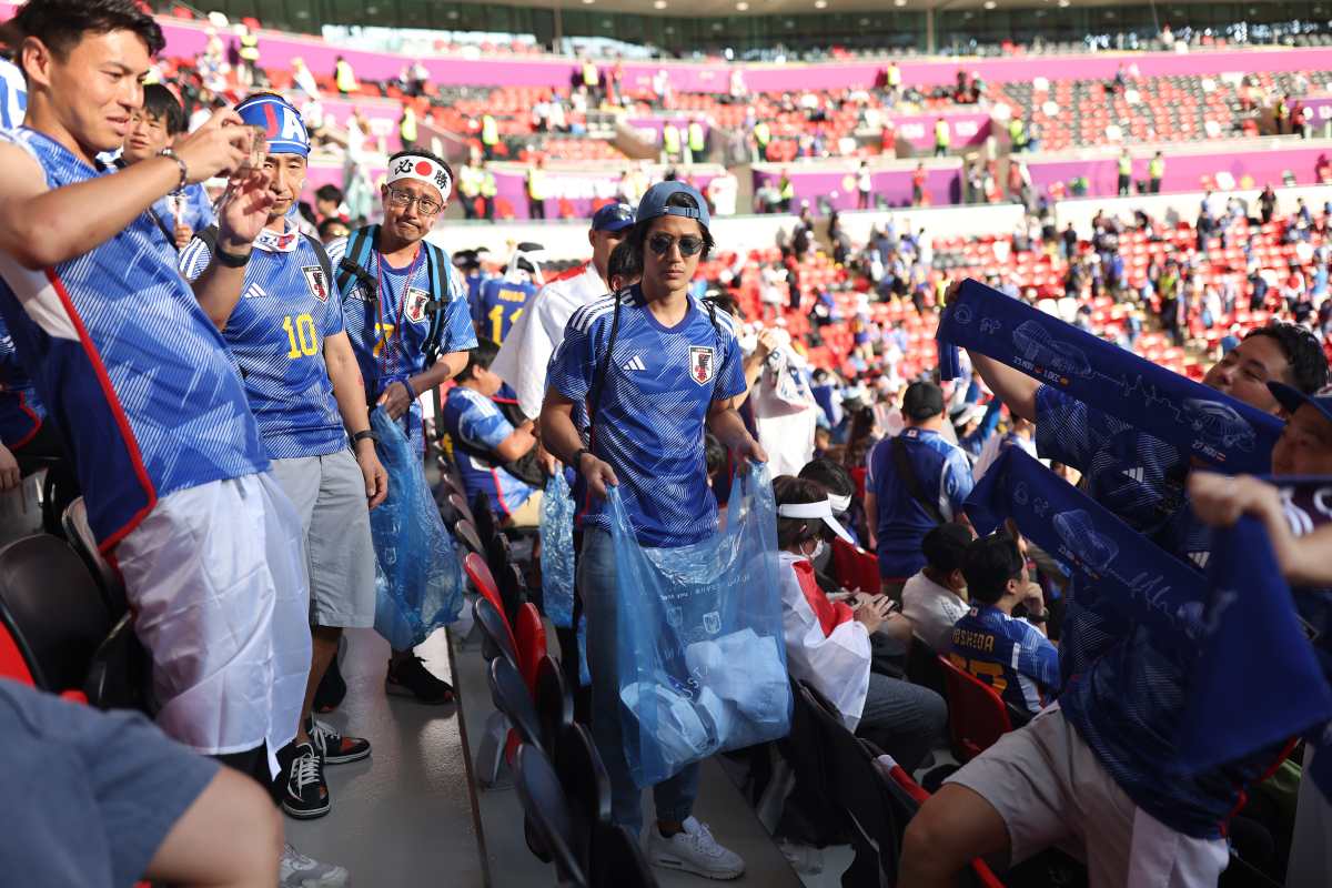 Aficionados japoneses recogen la basura de las gradas tras el partido de Japón contra Costa Rica en el Mundial de Doha, Qatar, el 27 de noviembre de 2022. (Foto Prensa Libre: Tasneem Alsultan/The New York Times)