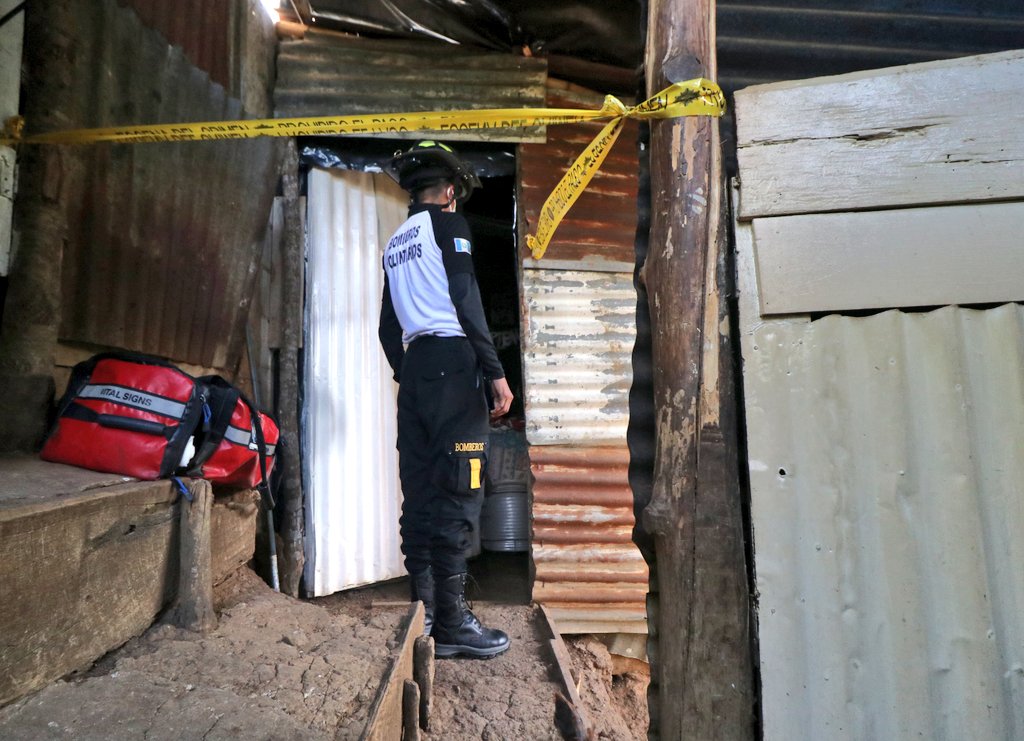 Un bombero observa hacia el interior de la vivienda en la que se encontró a la pareja de esposos, sin vida, en la aldea Colmenas, Villa Canales. (Foto Prensa Libre: Bomberos Voluntarios)
