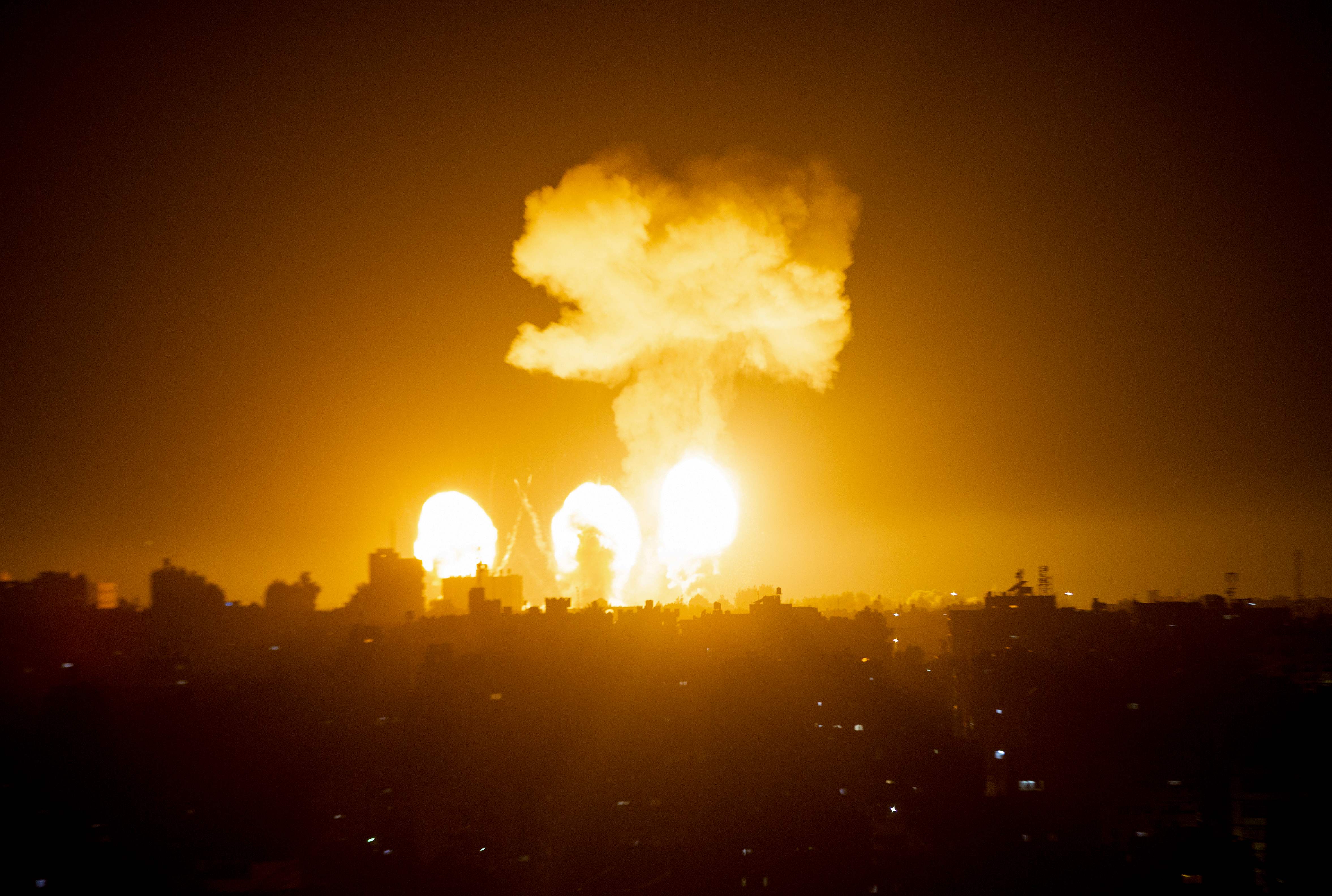A ball of fire and a plume of smoke rise above buildings in south of City Strip as Israeli warplanes target the Palestinian enclave, early on, on December 4, 2022. (Photo by AFP)