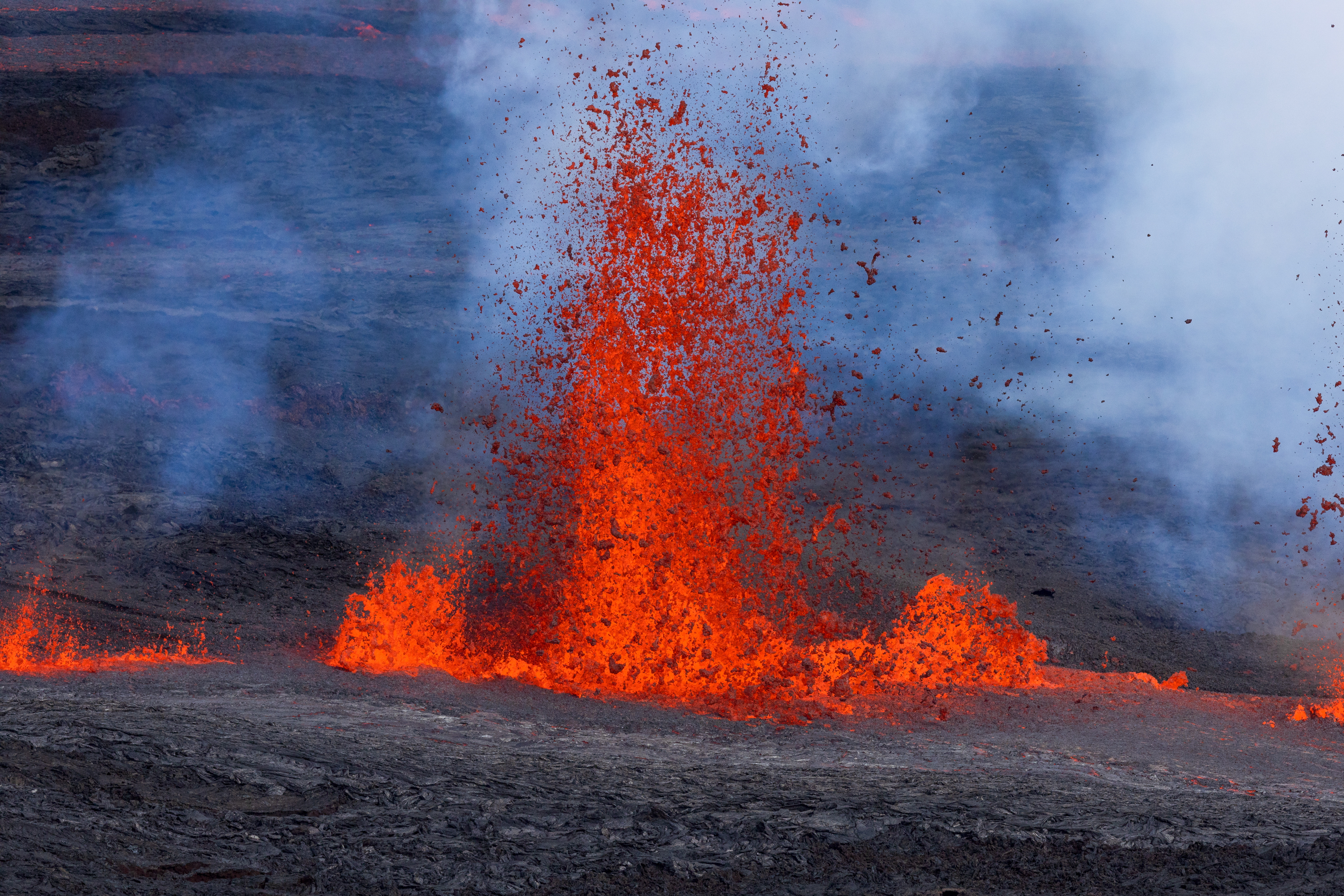 Imagen de una cascada de lava fluyendo desde el interior del cráter Mokuaweoweo por la grieta noreste del volcán Mauna Loa, en la isla de Hawái. (Foto Prensa Libre: EFE)