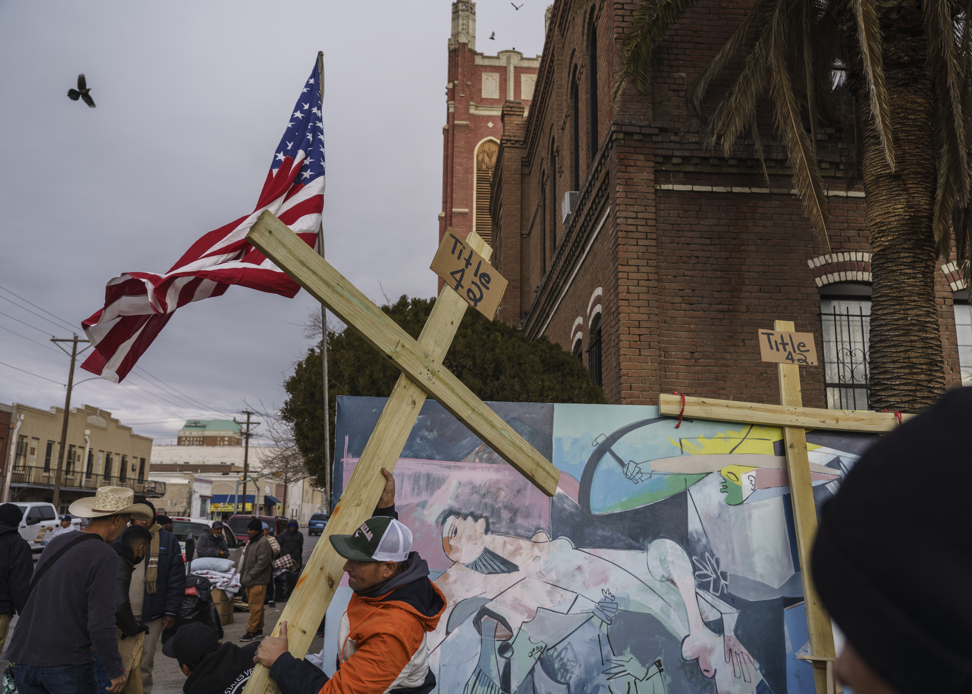 Migrantes preparan cruces para una protesta contra el Título 42, la medida de expulsión destinada a frenar el creciente número de migrantes que entran ilegalmente en Estados Unidos, en El Paso, Texas, el 28 de diciembre de 2022. (Foto Prensa Libre: Paul Ratje/The New York Times)