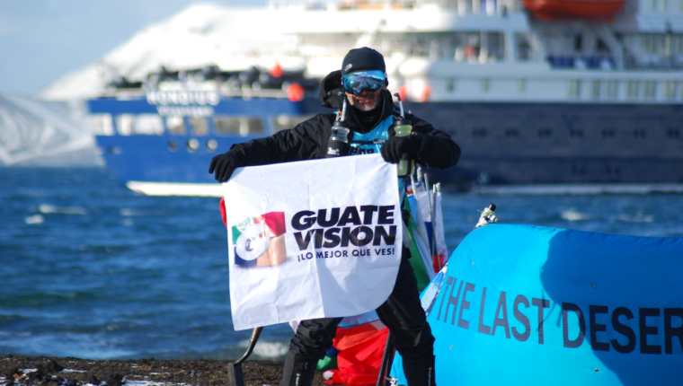 Miguel Sagastume muestra el logo de Guatevisión durante su estancia en la Antártida. (Foto Prensa Libre: Cortesía) 