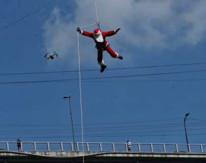 En imágenes: Santa llega desde lo alto de un puente para entregar juguetes a los niños