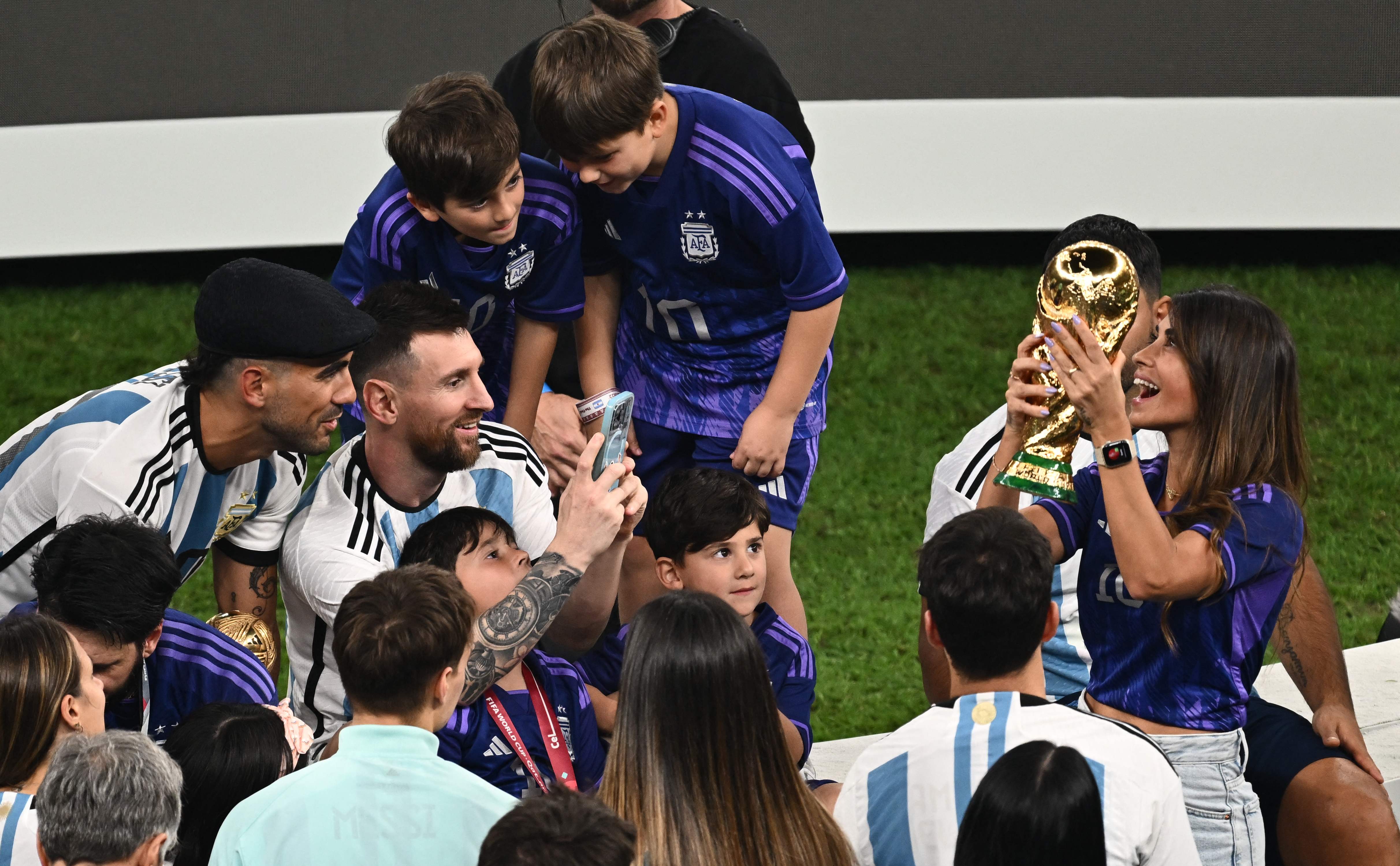 Lionel Messi le toma una foto a Antonela Roccuzzo con la Copa del Mundo. (Foto Prensa Libre: AFP)