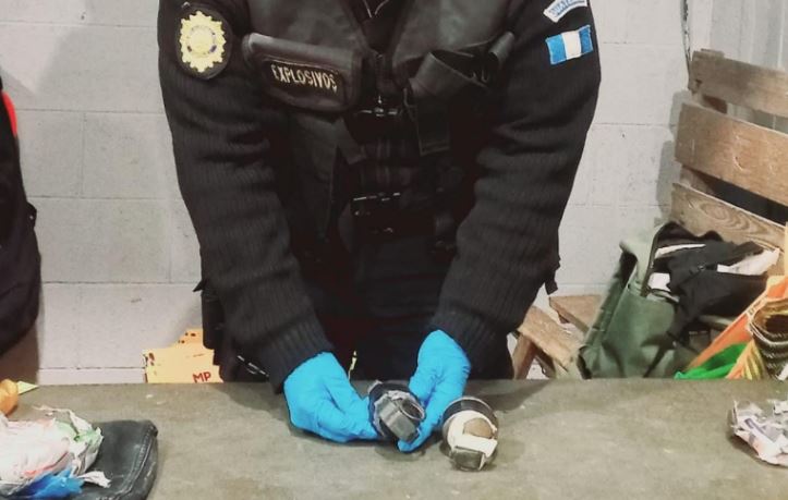 Un agente de la PNC, especialista en explosivos, inspecciona y asegura  una de las dos granadas de fragmentación que fueron decomisadas a un reo en la cárcel Pavoncito. (Foto Prensa Libre: PNC)