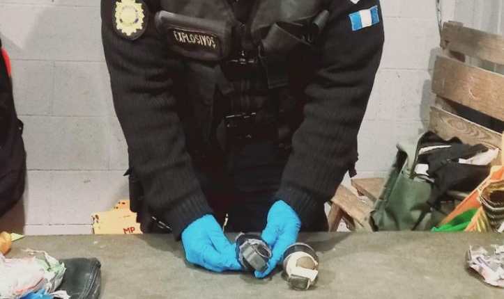 Un agente de la PNC, especialista en explosivos, inspecciona y asegura  una de las dos granadas de fragmentación que fueron decomisadas a un reo en la cárcel Pavoncito. (Foto Prensa Libre: PNC)