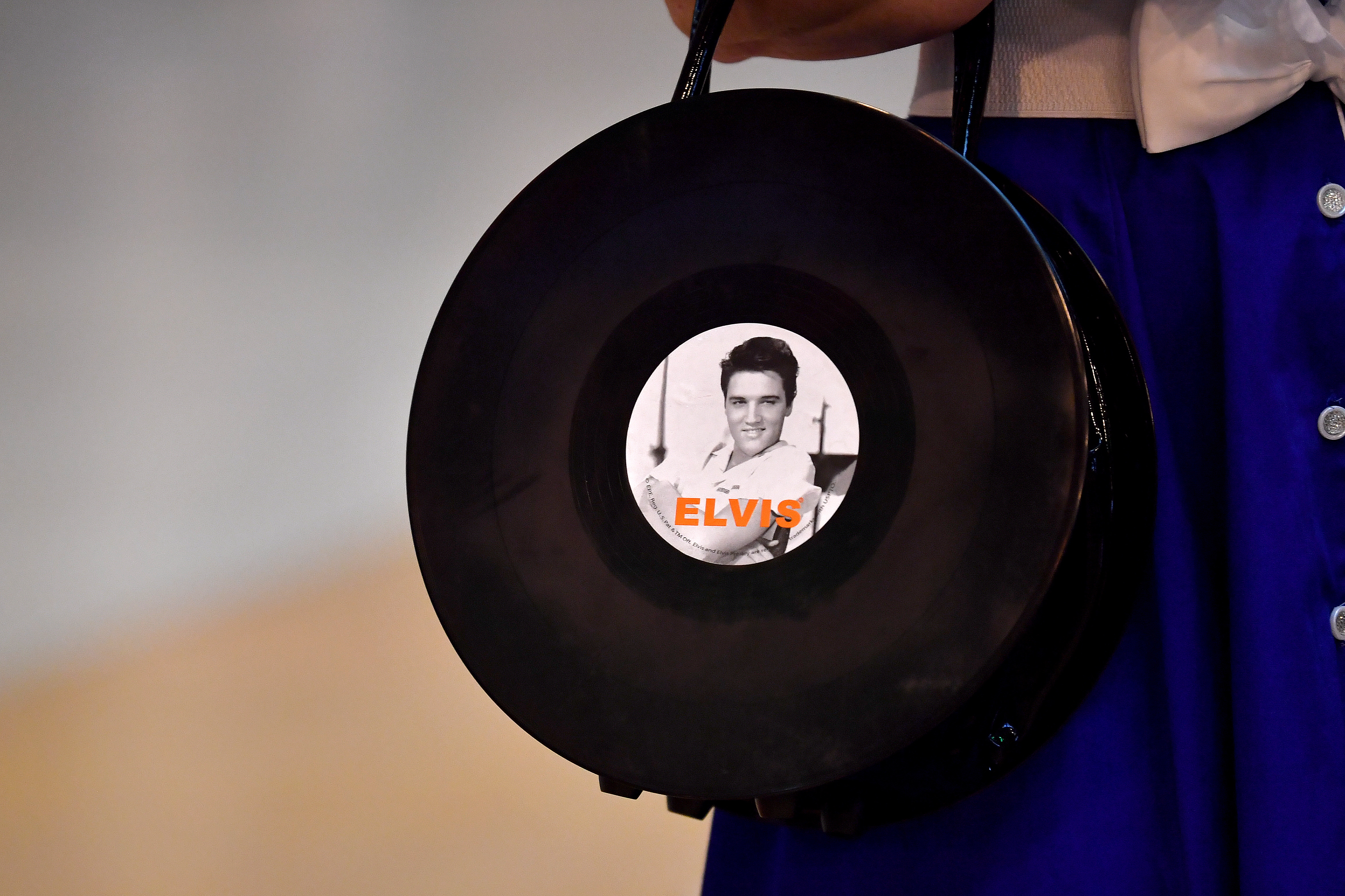 Fans disfrazados con ropa inspirada en Elvis Presley.  La guitarra del artista será subastada.   (Foto Prensa Libre: EFE)