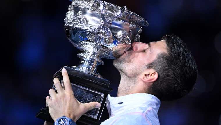 El tenista serbio Novak Djokovic besa la Copa Challenge de Norman Brookes tras ganar la final individual masculina contra el griego Stefanos Tsitsipas en el torneo de tenis Abierto de Australia 2023. Foto Prensa Libre (EFE)