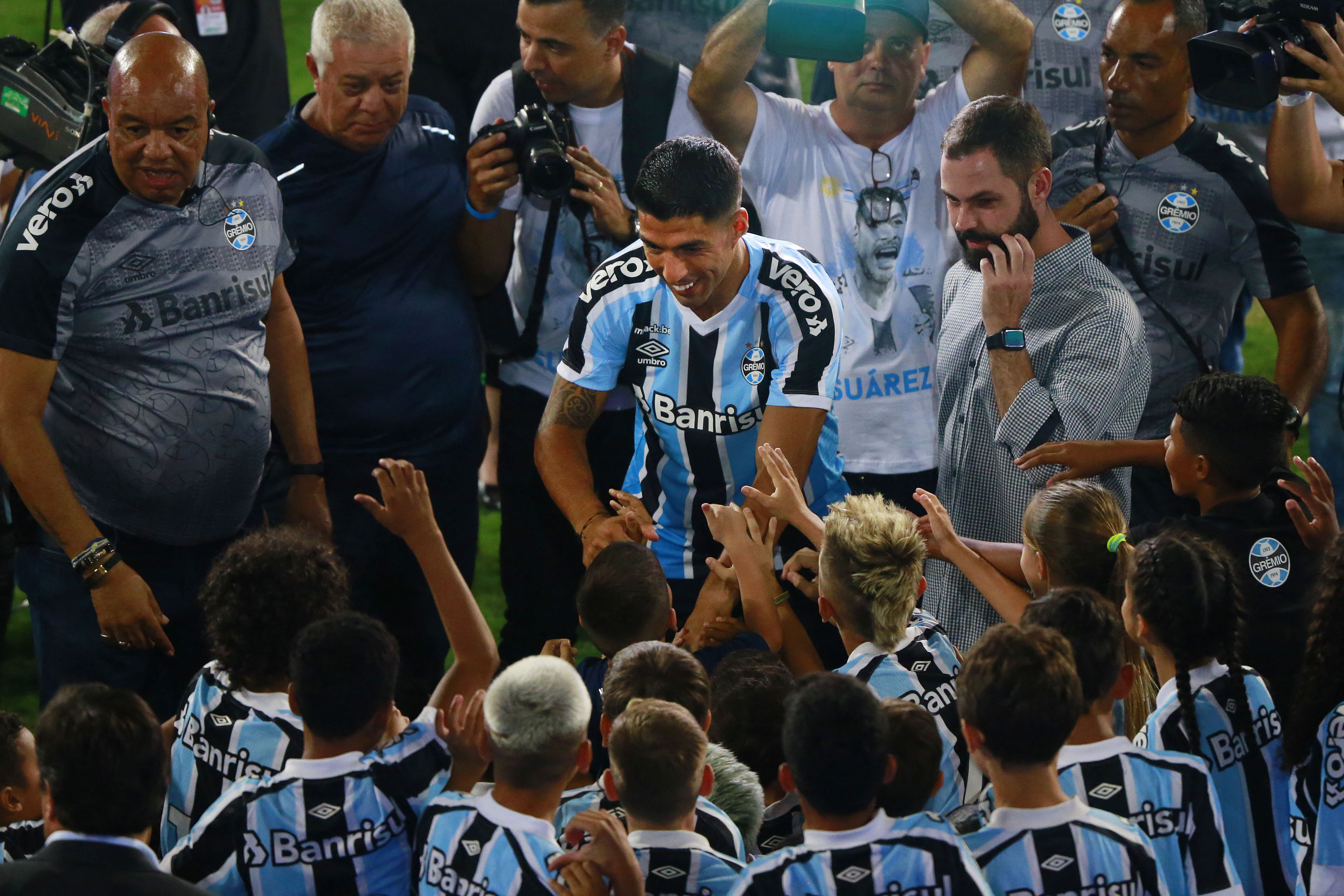 El uruguayo  Luis Suarez saluda a algunos aficionados durante la presentación oficial con el club Gremio, de Porto Alegre. (Foto Prensa Libre: AFP).