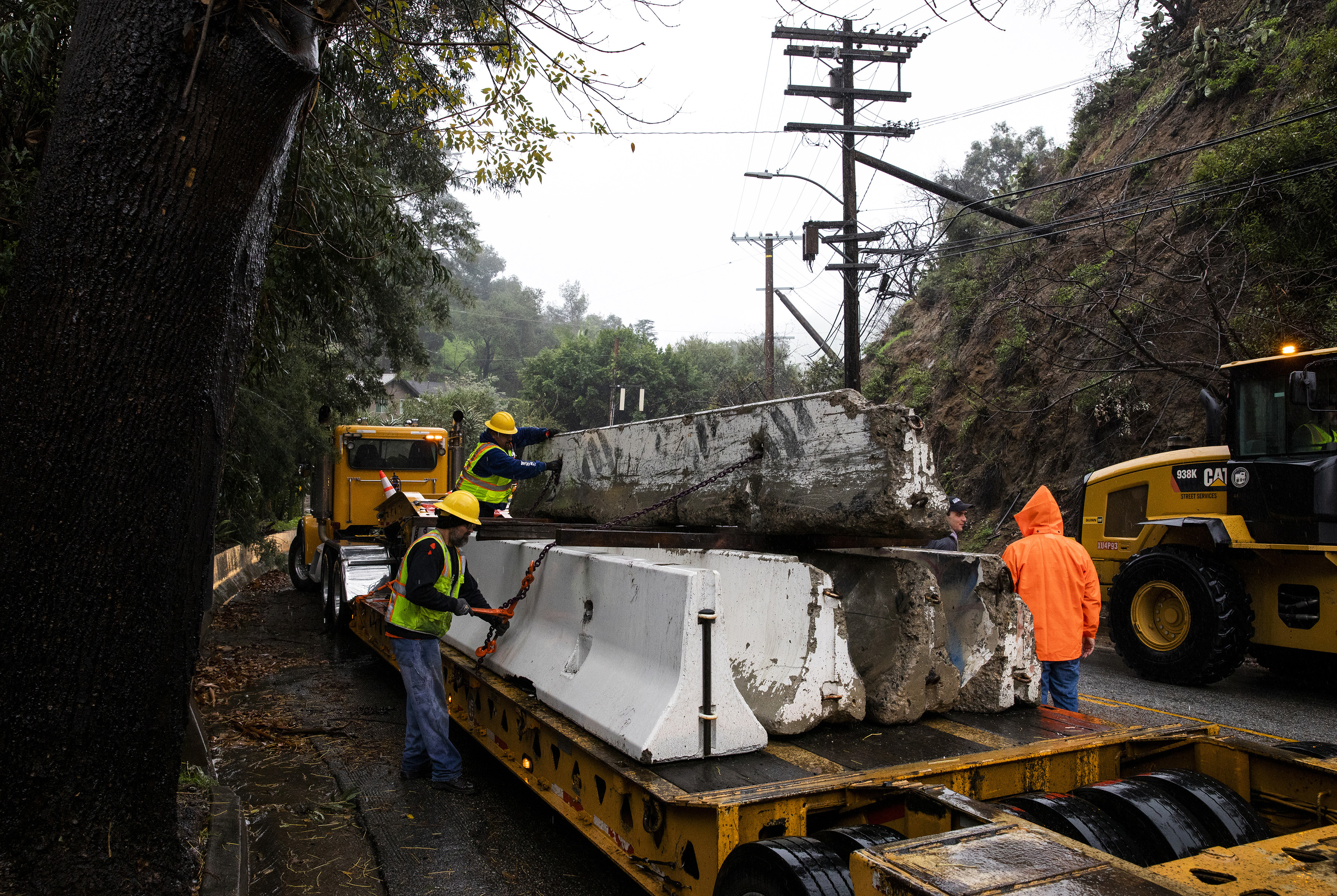 Trabajadores colocan barreras de hormigón para desviar el barro y los escombros de la calzada en Los Ángeles el miércoles 4 de enero de 2023. (Foto Prensa Libre: Alisha Jucevic/The New York Times)