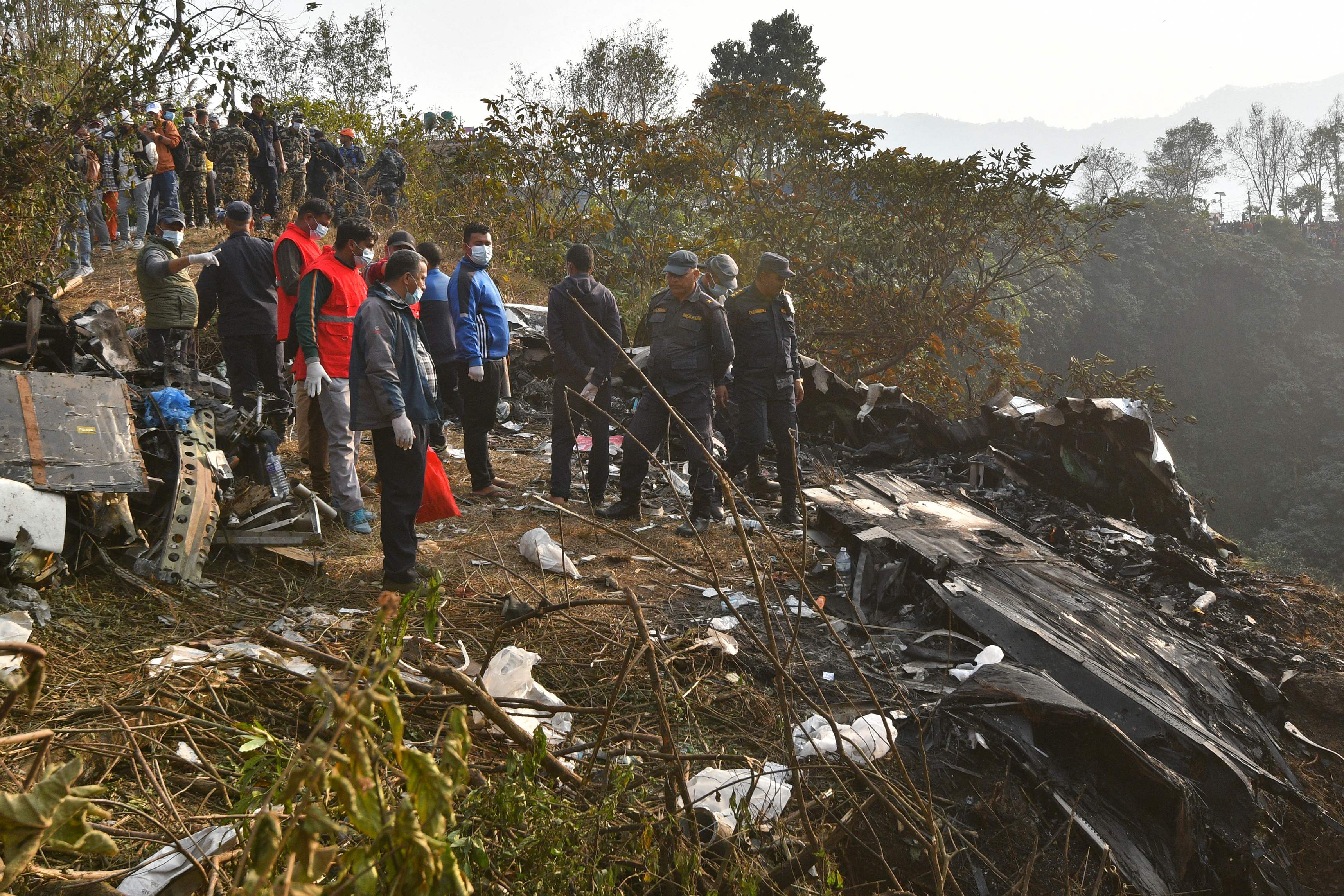 Socorristas continúan buscando cuerpos de víctimas que viajaban en un avión accidentado en Nepal. (Foto Prensa Libre: AFP)