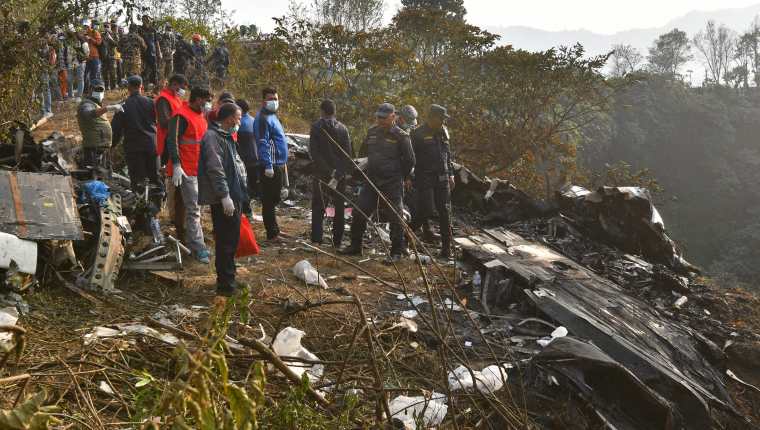 Socorristas continúan buscando cuerpos de víctimas que viajaban en un avión accidentado en Nepal. (Foto Prensa Libre: AFP)