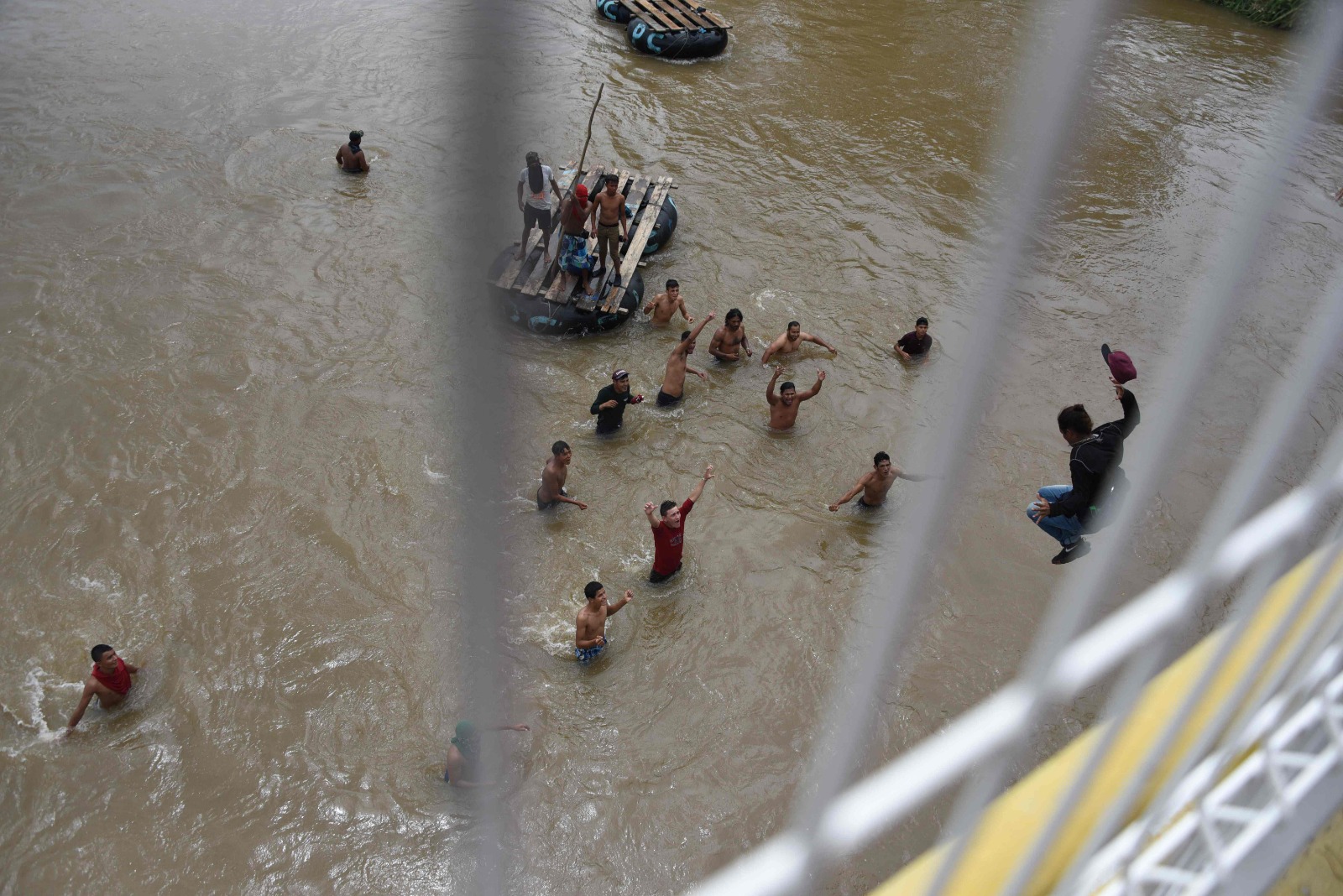 Migrantes saltan al río Suchiate desde el puente fronterizo Guatemala-México en Tecún Umán cuando una "avalancha" intentaba cruzar en caranava a finales de 2018. (Foto Prensa Libre: AFP)