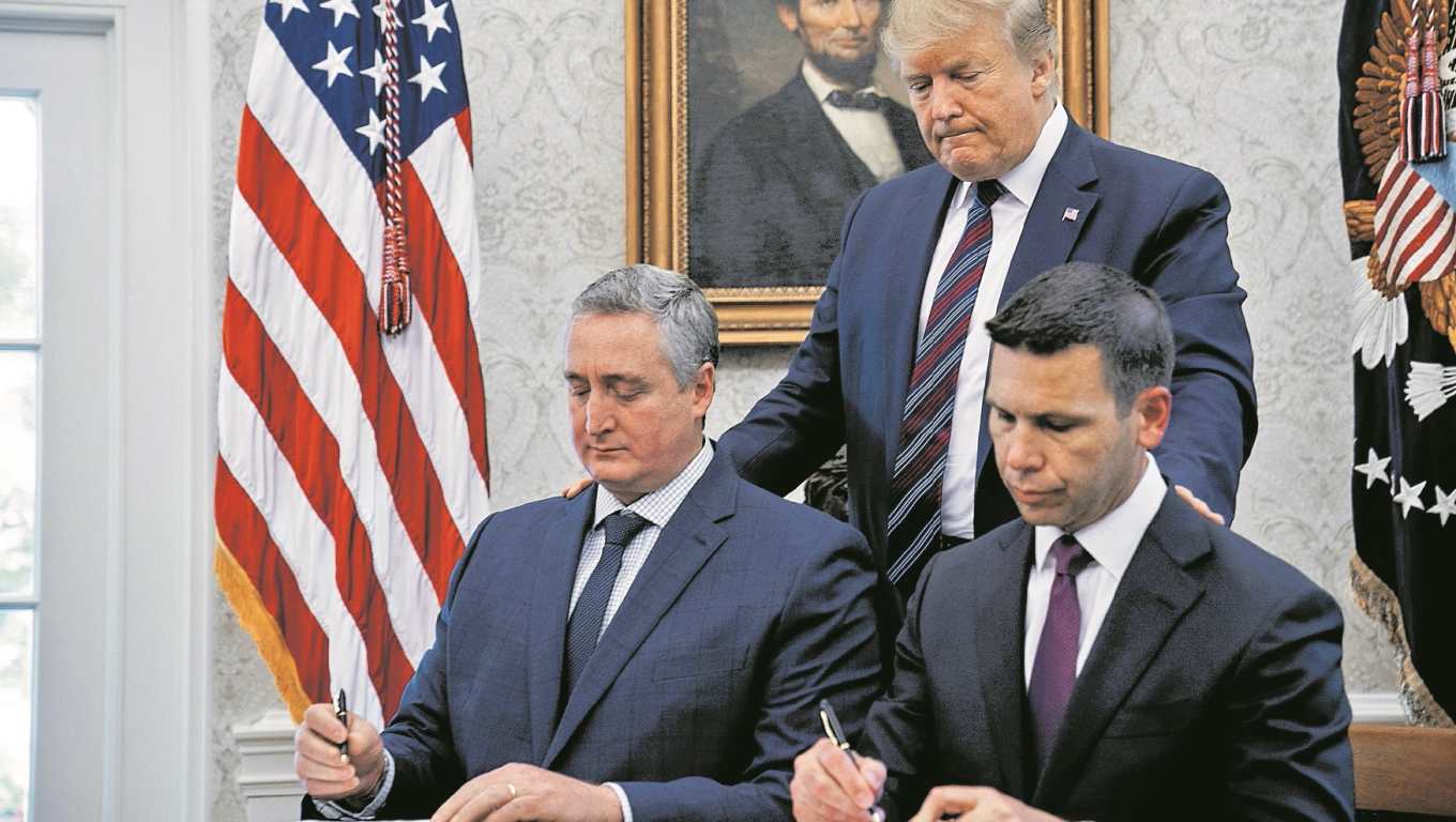 El exministro de Gobernación de Guatemala, Enrique Degenhart, y el exsecretario de Seguridad Nacional de EE. UU., Kevin McAleenan, firman el acuerdo, ante la presencia del expresidente Trump. (Foto Prensa Libre: Hemeroteca PL)
