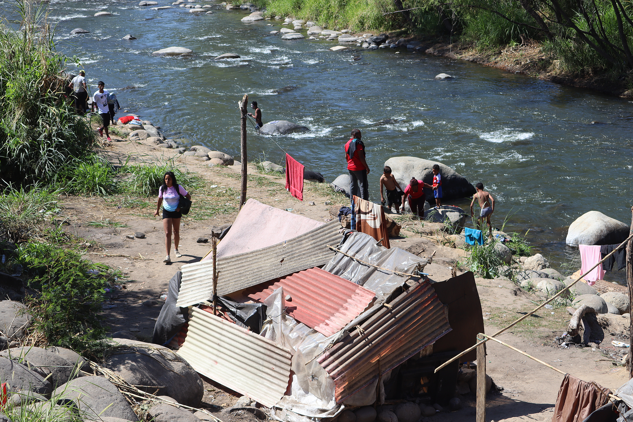 Grupos de personas migrantes se establecen en un campamento improvisado a orillas del Río Coatán hoy, en la ciudad de Tapachula, estado de Chiapas, México. (Foto Prensa Libre: EFE)