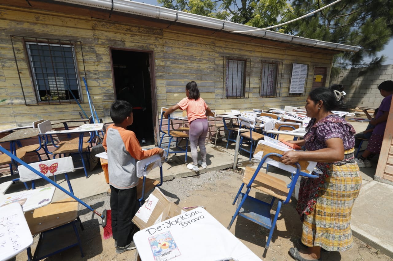 Los padres de familia arreglaron los escritorios que recogieron entre los que estaban descartados, durante el primer día de clases el pasado 20 de febrero de 2023. (Foto Prensa Libre: María José Bonilla)