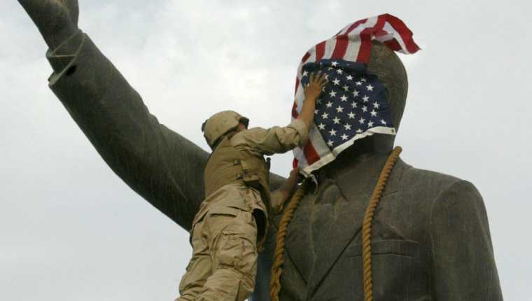 Un infante de marina estadounidense cubre el rostro de la estatua de Saddam Hussein en Bagdad días después de la invasión. La estatua luego fue derribada, convirtiéndose en una símbolo del derrocamiento del líder iraquí.

GETTY IMAGES

