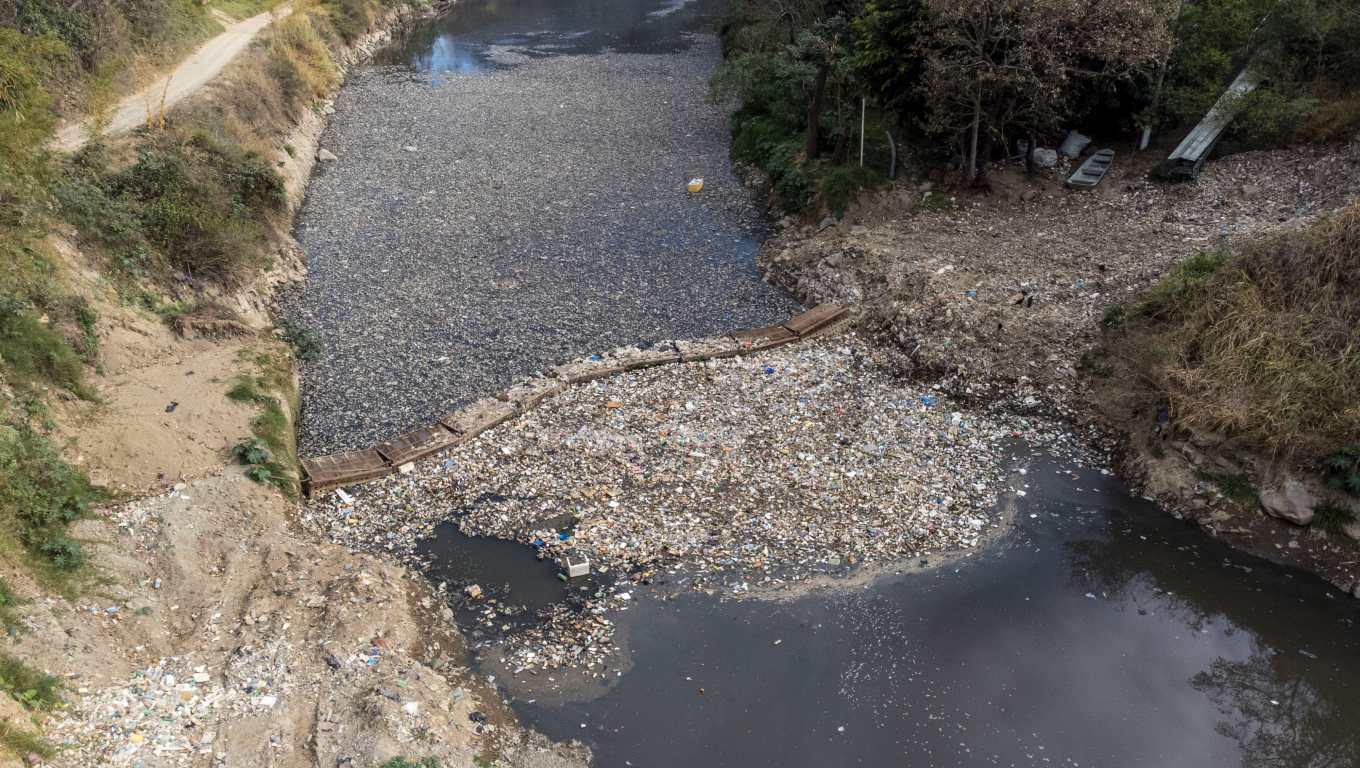 ACOMPAÑA CRÓNICA AME3154. CHINAUTLA (GUATEMALA), 17/03/2023.- Fotografía con drone del 10 de marzo 2023, de una biobarda que intenta contener cientos de toneladas de basura que atraviesan el río Las Vacas, provenientes de la Ciudad de Guatemala, en Chinautla (Guatemala). Guatemala tiene el doble de disponibilidad de agua que el promedio mundial, pero el 90 % de sus fuentes están contaminadas y millones de personas sufren un calvario diariamente para obtenerla, debido a décadas de una deficiente administración estatal. EFE/Esteban Biba