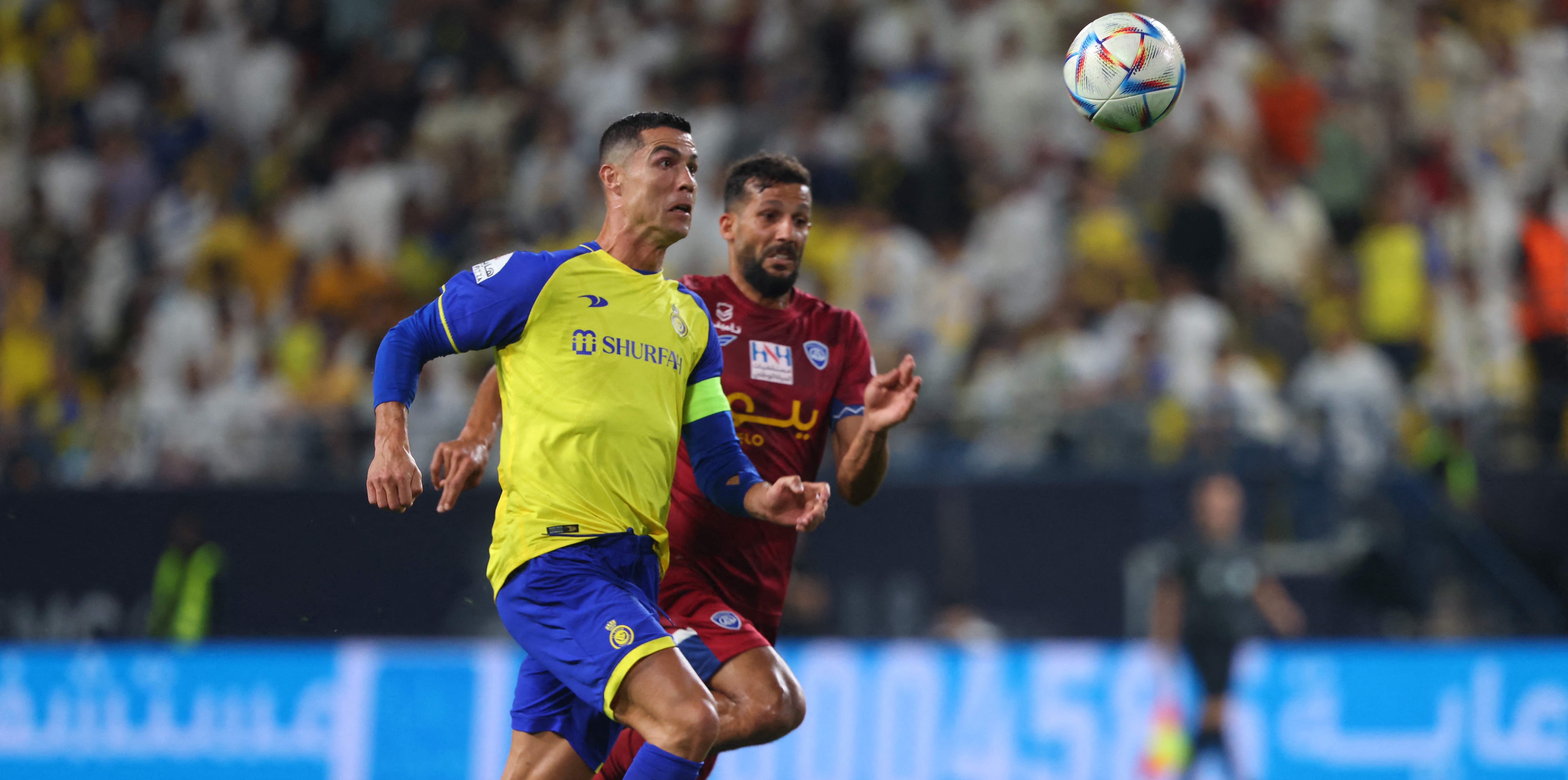 El delantero portugués de Nassr, Cristiano Ronaldo (frente) está marcado por el defensor iraquí de Abha, Saad Natiq, durante el partido de fútbol de la Liga Pro Saudita entre Abha y al-Nassr. Foto Prensa Libre (AFP)