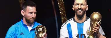 El delantero argentino Lionel Messi se encuentra junto a una estatua de sí mismo durante un homenaje de Conmebol a Argentina por su título de la Copa Mundial de Qatar 2022, celebrado antes del sorteo de las fases de grupos de los torneos de fútbol Libertadores y Sudamericana, en la sede de Conmebol. Foto Prensa Libre (AFP)