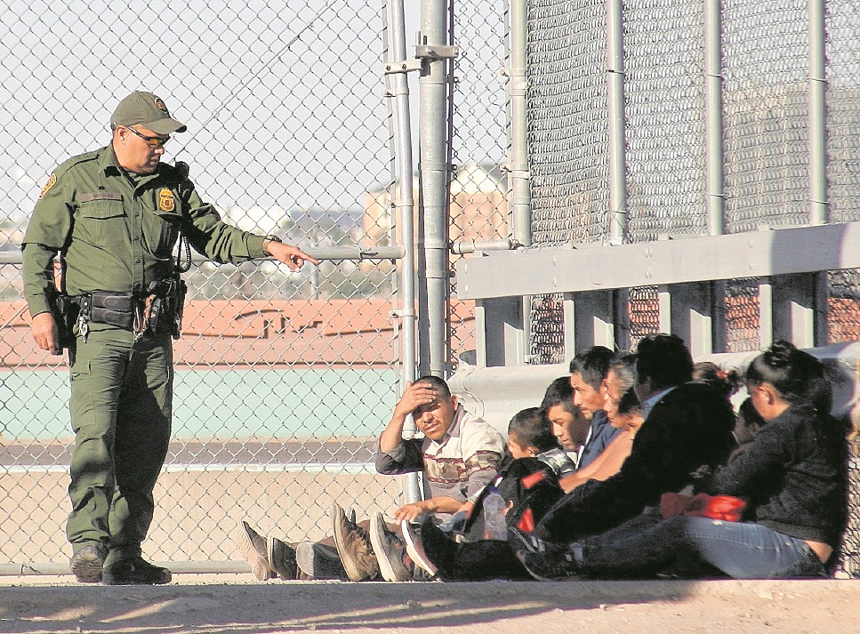 Un guardia de la Patrulla Fronteriza de EE. UU. inspecciona a un grupo de migrantes recién llegados a la frontera sur. (Foto Prensa Libre: EFE)