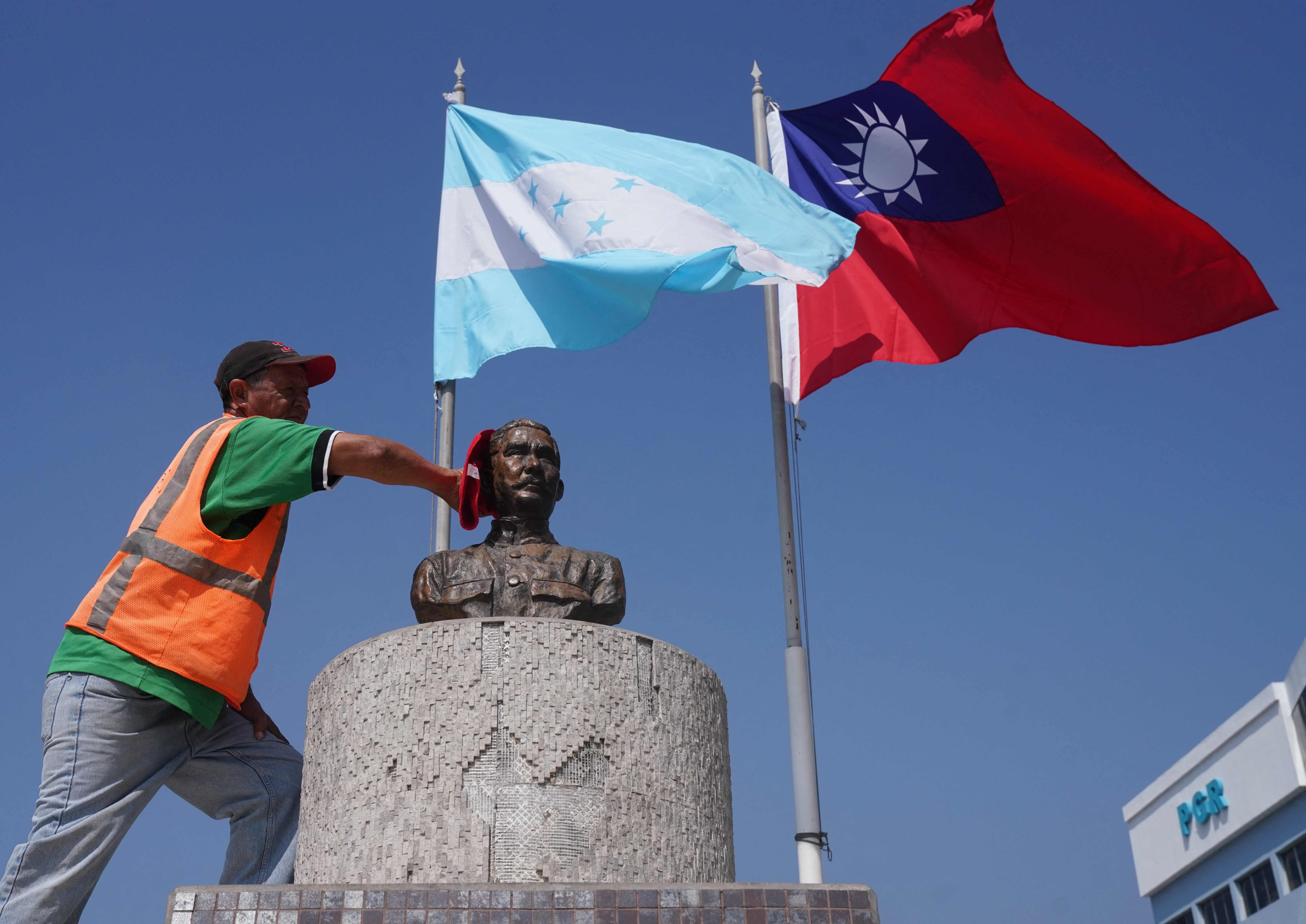 Un trabajador municipal limpia el busto del expresidente de Taiwán Sun Yat-sen, colocado en la plaza República de China (Taiwán), donde aún se observa la bandera de esta isla. (Foto Prensa Libre. AFP)