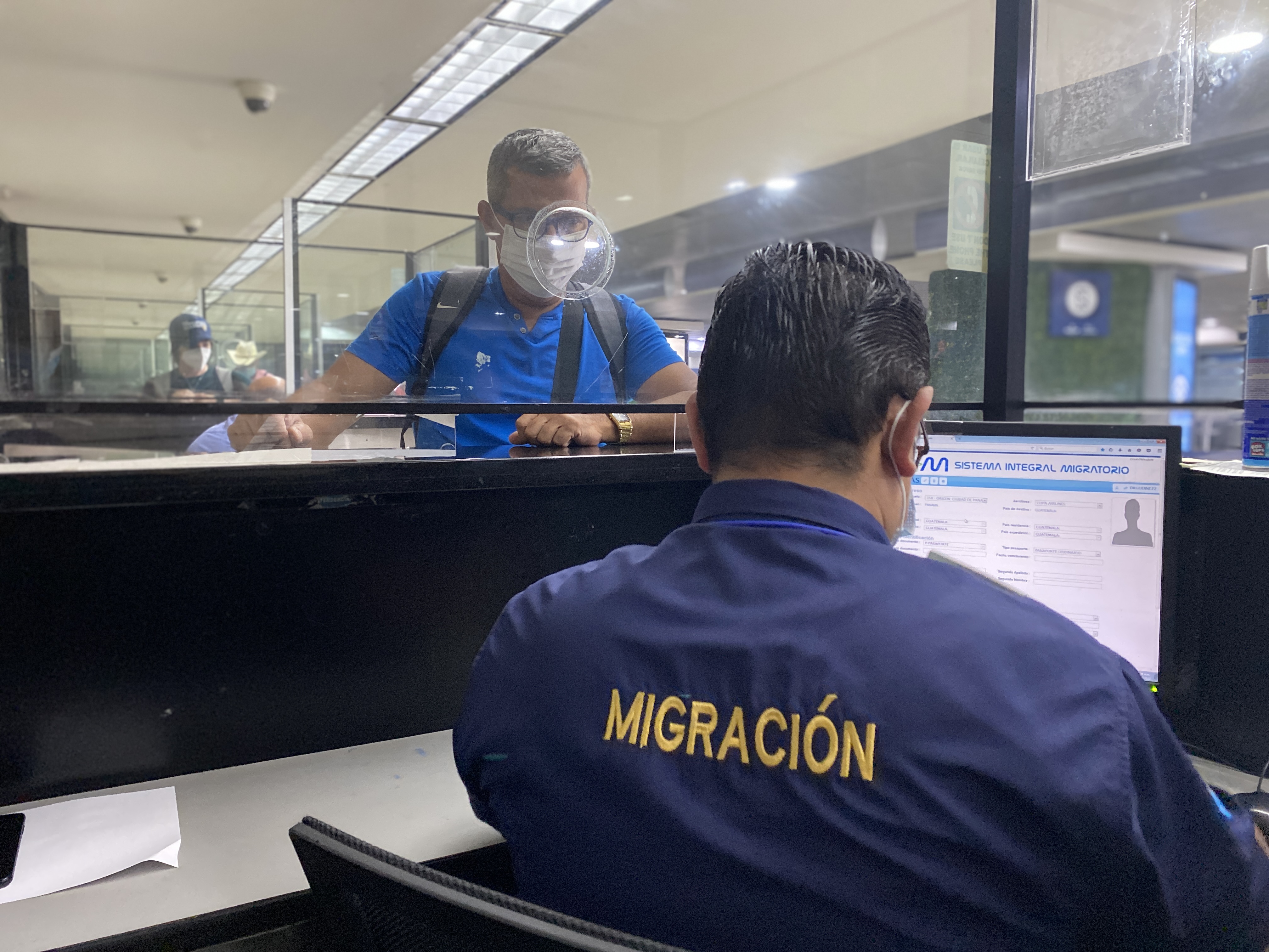 Un oficial guatemalteco de Migración registra el ingreso de una persona en el Aeropuerto Internacional La Aurora.  (Foto Prensa Libre: IGM)